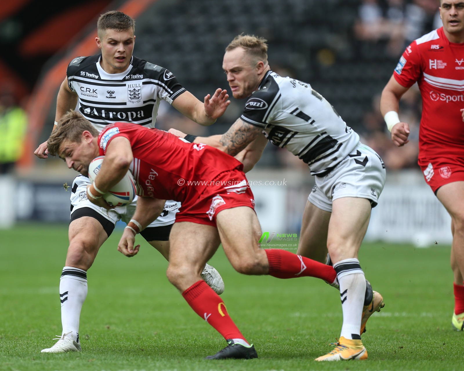 Adam Swift (21) of Hull FC grabs hold of Jimmy Keinhorst (33) of Hull KR