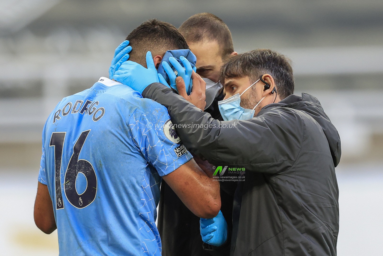 Rodri #16 of Manchester City receives treatment after receiving a blow to the face