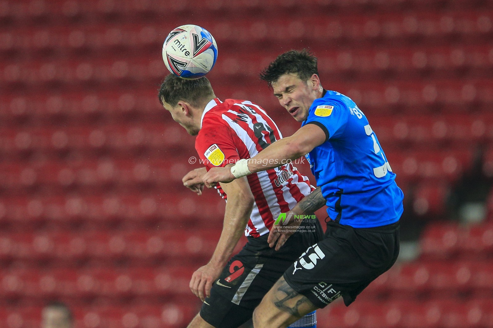 Charlie Wyke #9 of Sunderland in an aerial challenge with Tom Broadbent #33 of Swindon Town