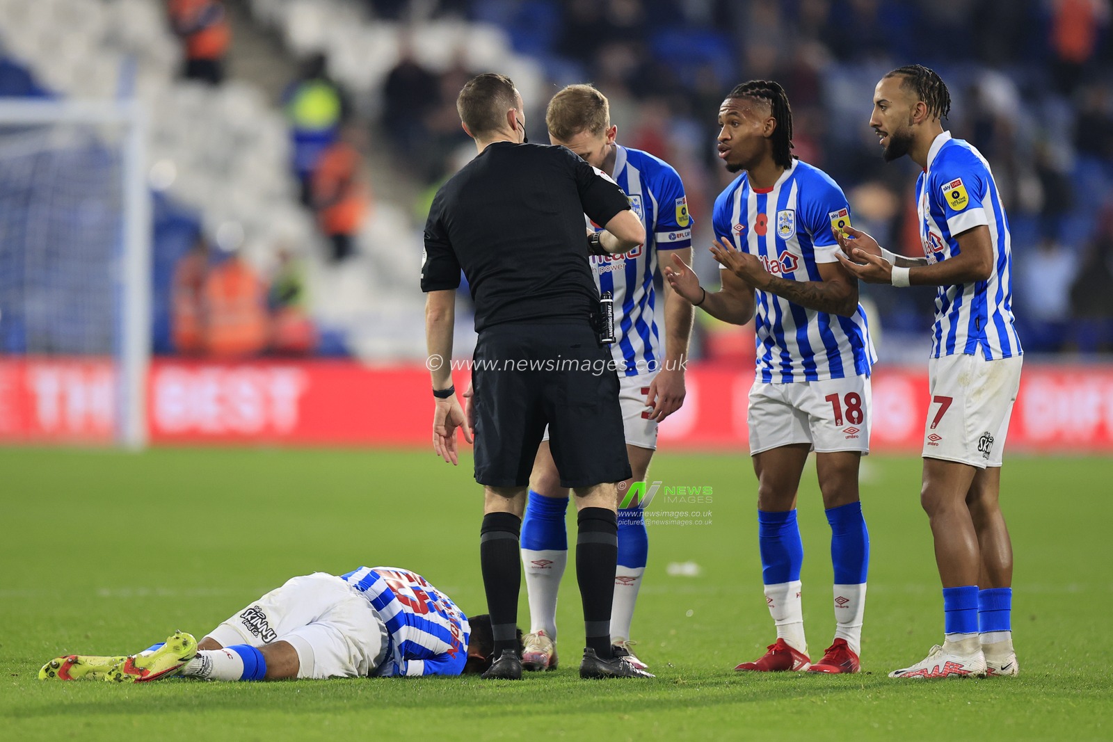 Kaine Kesler-Hayden #16 of Huddersfield Town lies injured as Sorba Thomas #7 and Kaine Kesler-Hayden #16 of Huddersfield Town have words with referee Ben Toner during the Sky Bet Championship match Huddersfield Town vs Swansea City at John Smith's Stadium, Huddersfield, United Kingdom, 12th November 2022

(Photo by Conor Molloy/News Images)