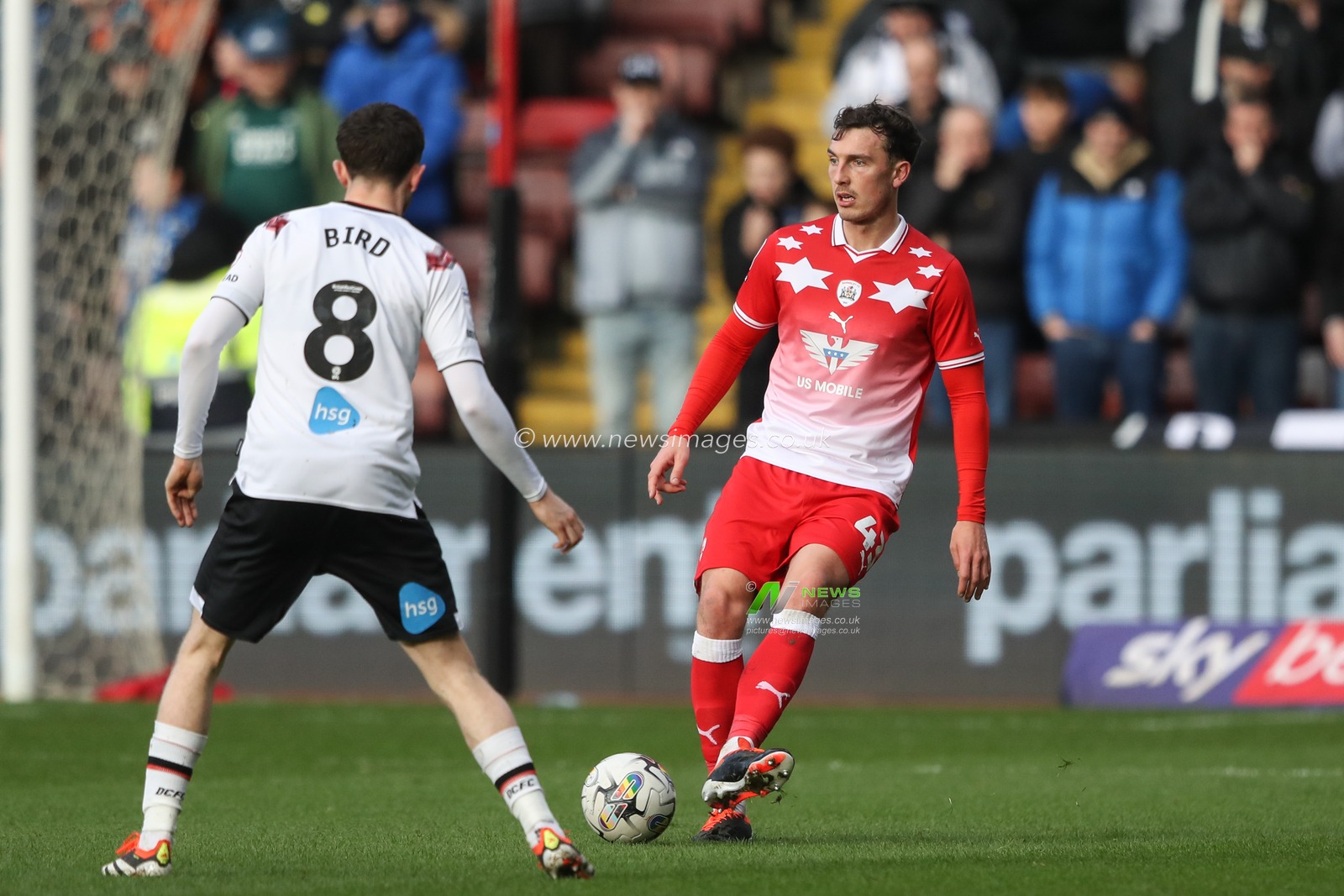 Josh Earl of Barnsley passes the ball under pressure from Max Bird of Derby County \during the Sky Bet League 1 match Barnsley vs Derby County at Oakwell, Barnsley, United Kingdom, 24th February 2024

(Photo by Alfie Cosgrove/News Images)