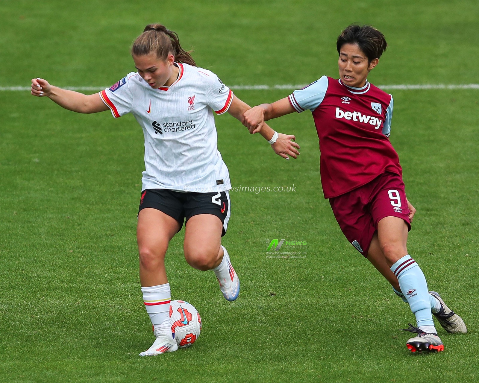 Lucy Parry of Liverpool is challenged by Riko Ueki of West Ham United during the The FA Women's Super League match West Ham United Women vs Liverpool Women at The Chigwell Construction Stadium, London, United Kingdom, 29th September 2024

(Photo by Izzy Poles/News Images)