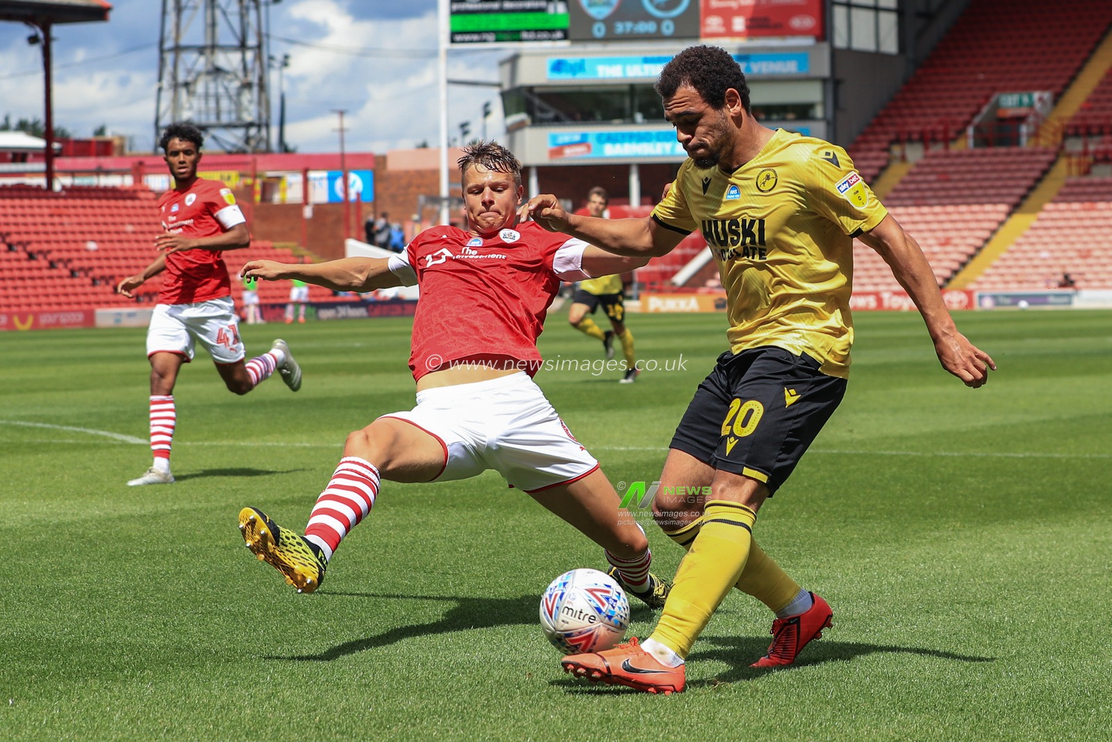 Mason Bennett (20) of Millwall crosses the ball into the box as Mads Andersen (6) of Barnsley slides in