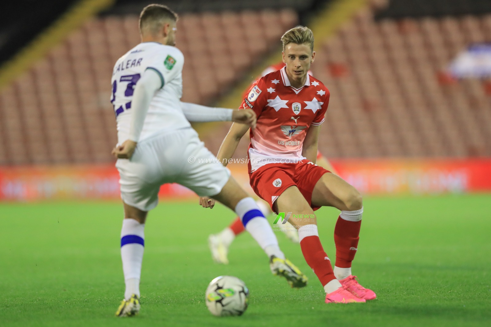 Reece McAlear of Tranmere Rovers holds the ball as Oli Shaw #14 of Barnsley pressures during the Carabao Cup match Barnsley vs Tranmere Rovers at Oakwell, Barnsley, United Kingdom, 8th August 2023

(Photo by Alfie Cosgrove/News Images)