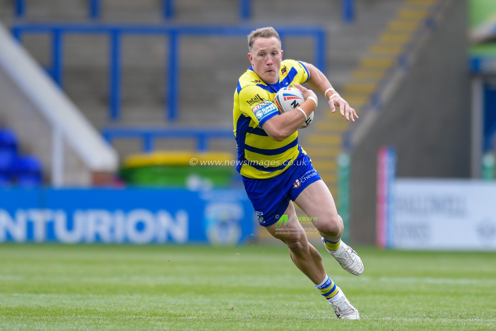 Jason Clark (14) of Warrington Wolves runs with the ball