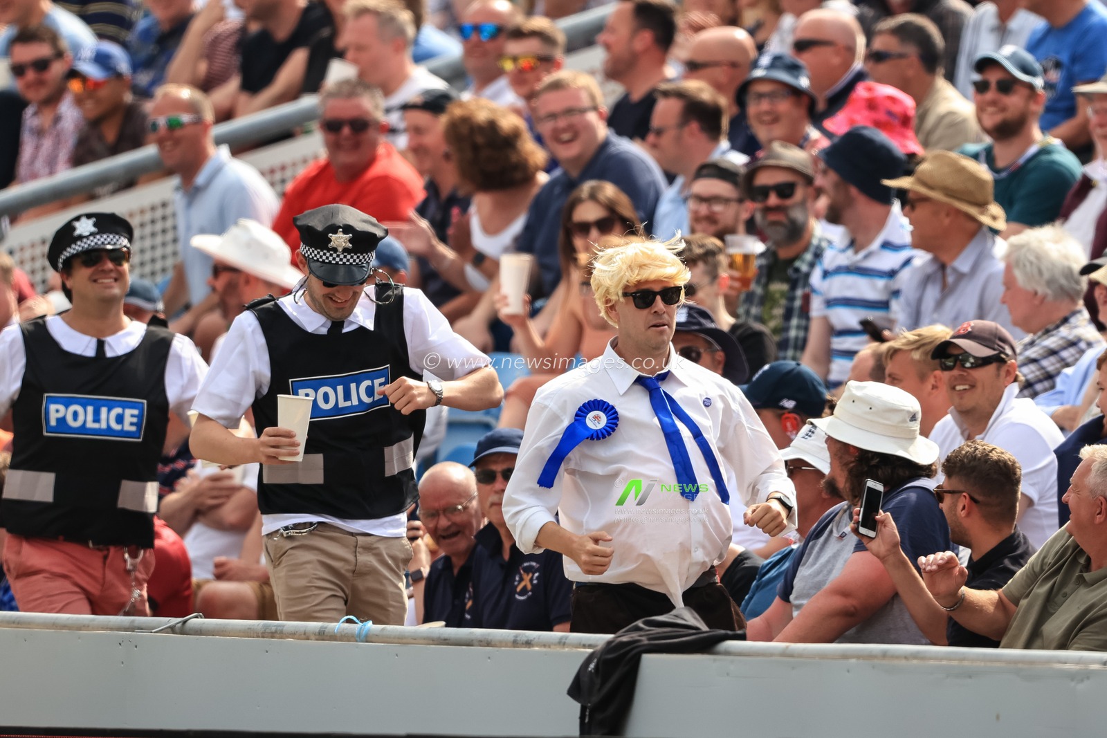 A man dressed as Boris Johnson runs away from his friends who are dressed as police as they chase him through the crowd, the whole of Headingley erupts with laughter