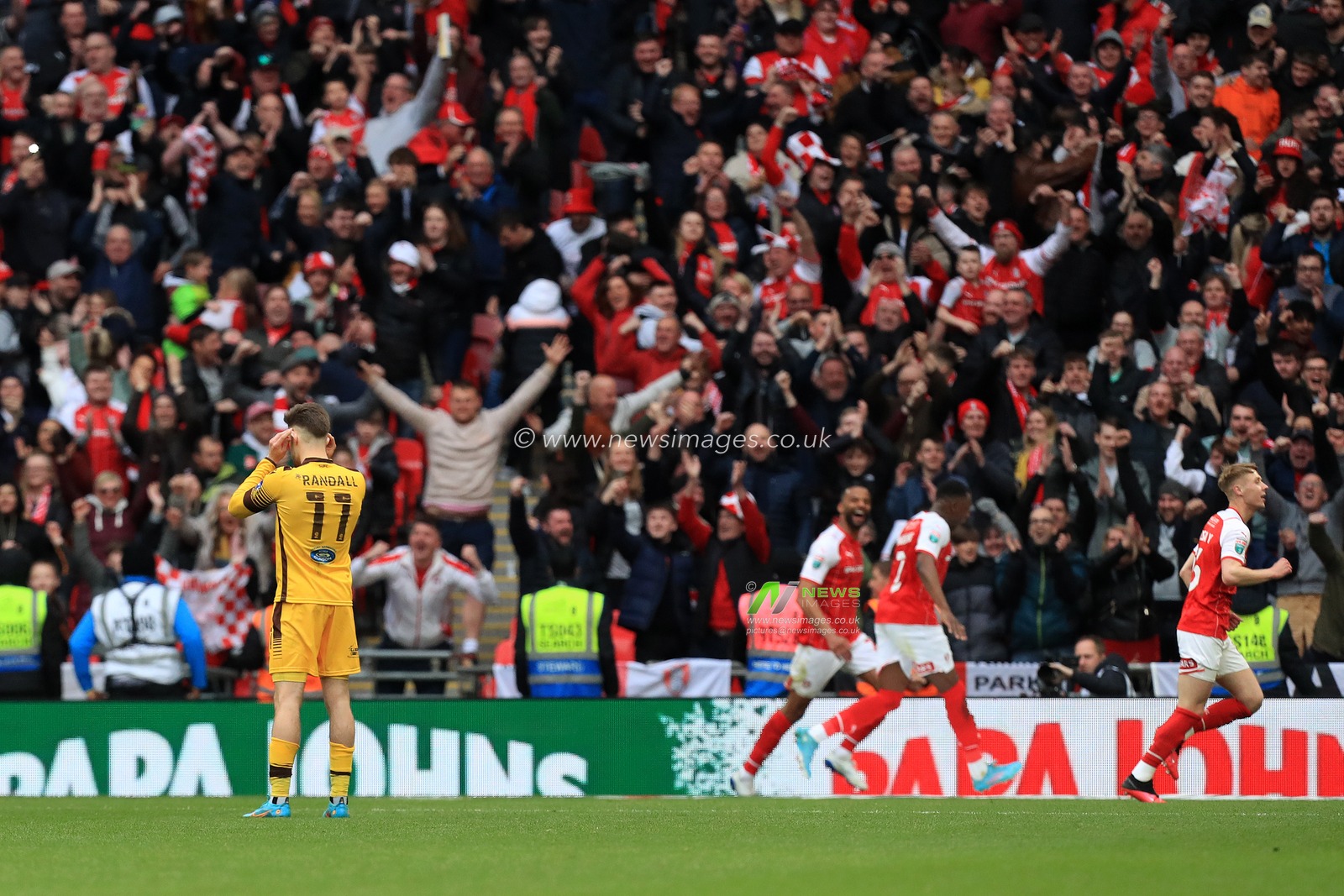 GOAL: A dejected Will Randall #11 of Sutton United sees Rotherham United players and fans celebrate the fourth goal.