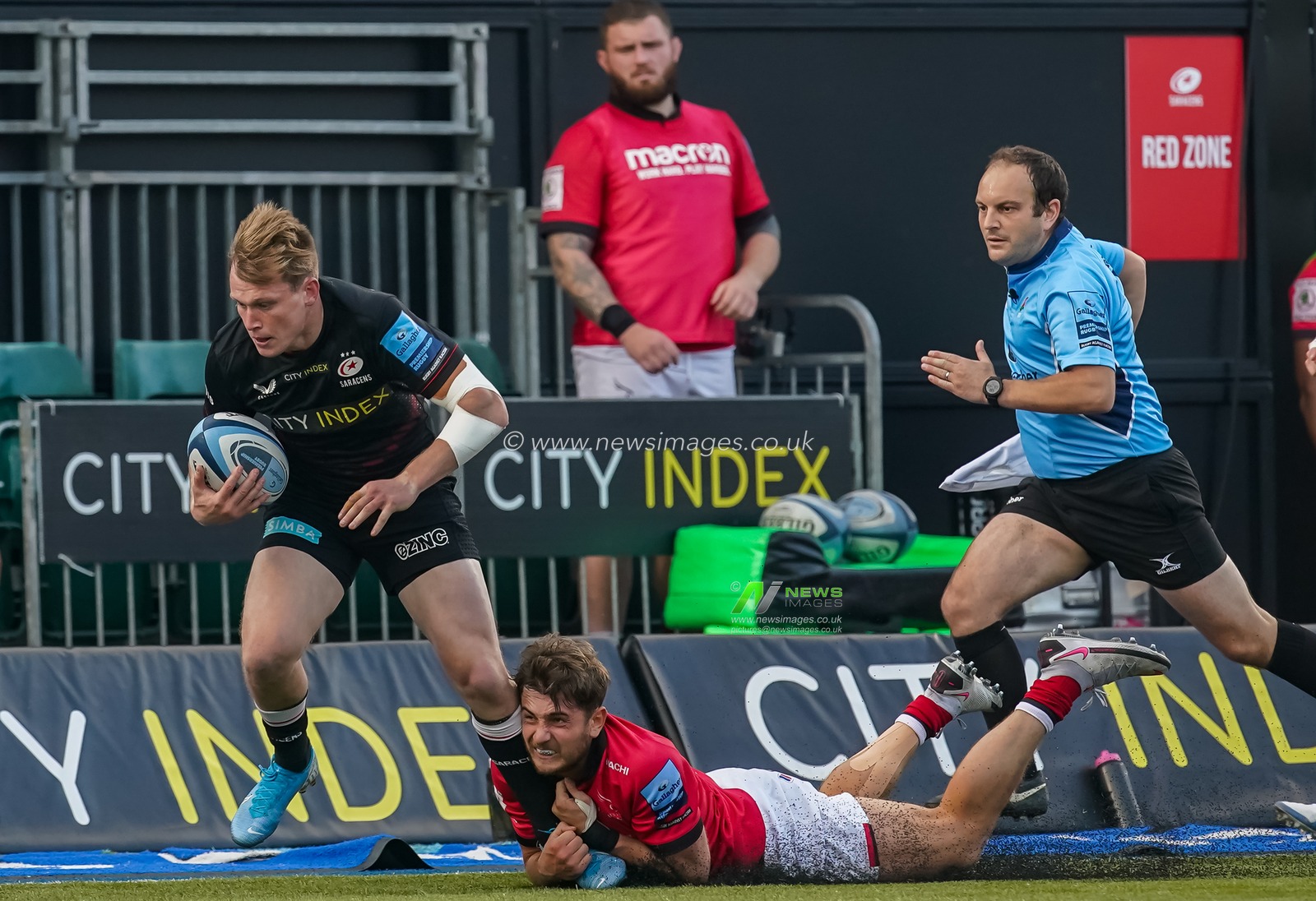 Ben Stevenson #13 of Newcastle Falcons tackles  Alex Lewington #14 of Saracens on the wing
