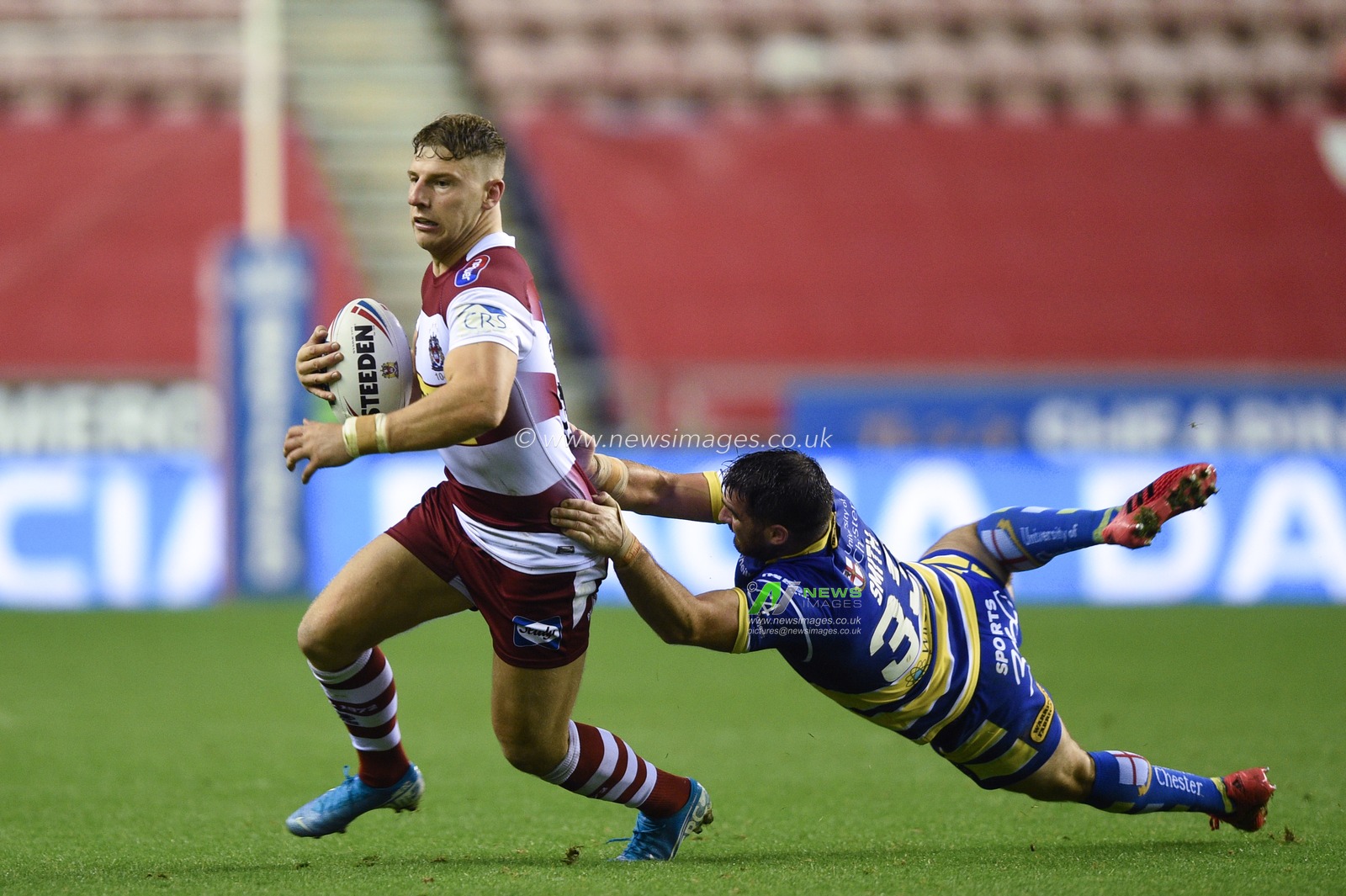 16th August 2019 , DW Stadium, Wigan, England;  Betfred Super League, Round 26, Wigan Warriors vs Warrington Wolves ; George Williams of Wigan Warriors is tackled by Matty Smith of Warrington Wolves 

Credit: Richard Long/News Images