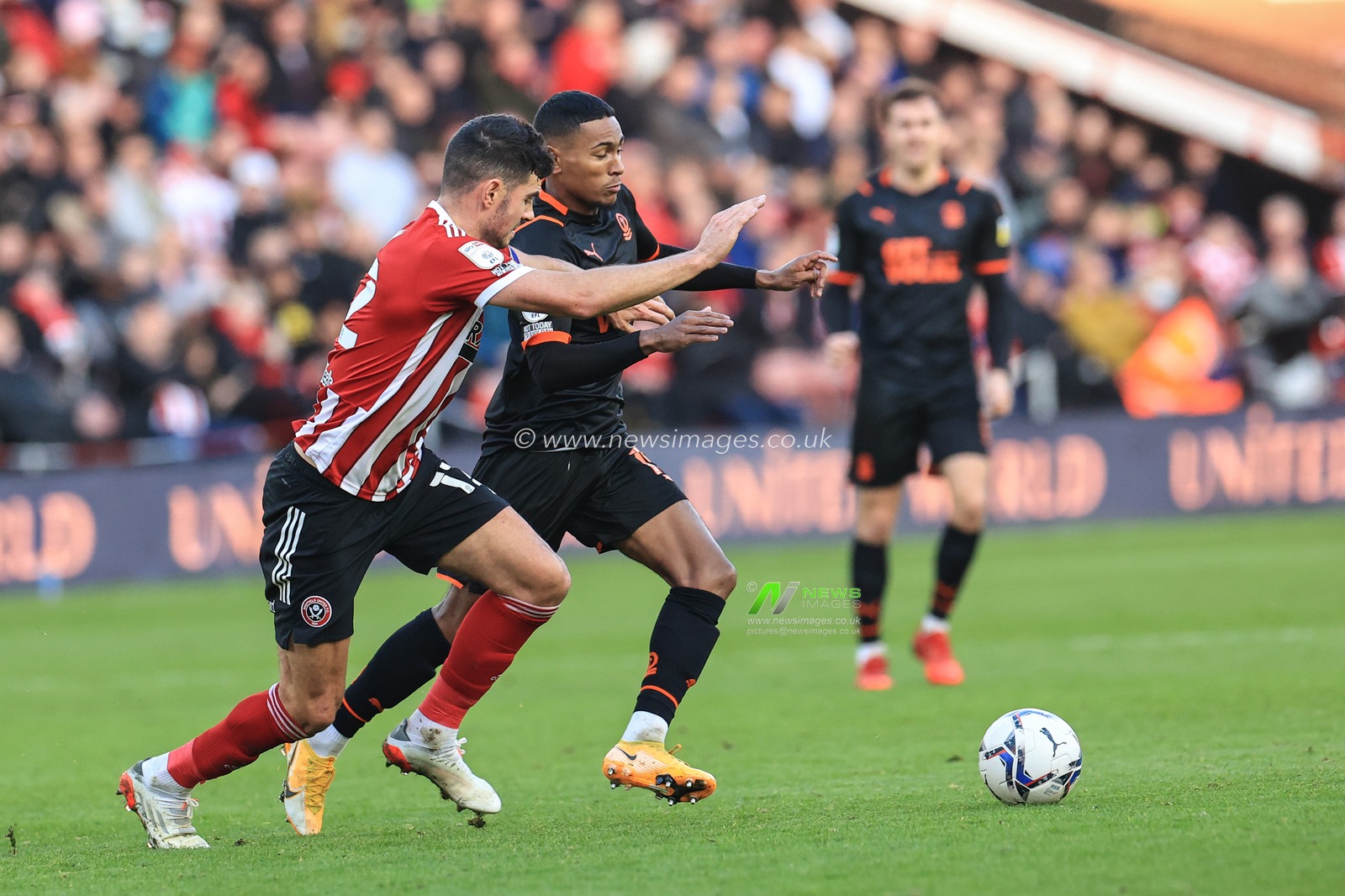 Demetri Mitchell #15 Of Blackpool holds the ball under pressure from John Egan #12 of Sheffield United