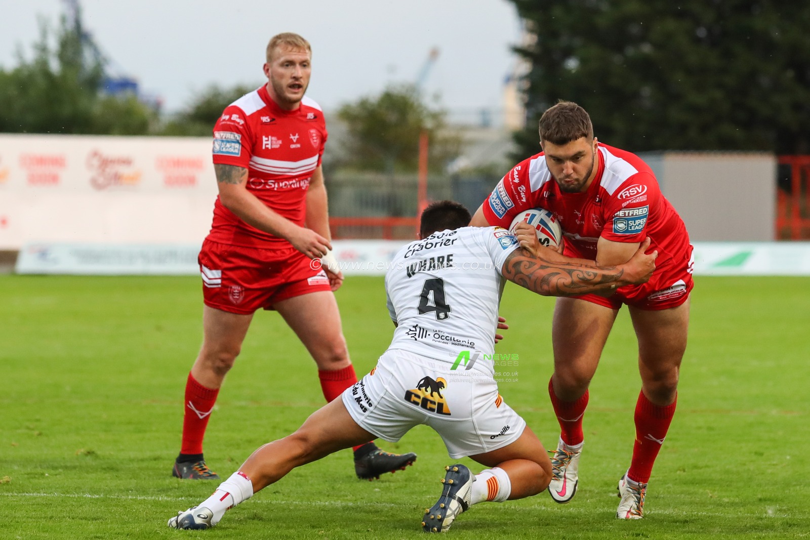 Matty Storton (18) of Hull KR runs at Dean Whare (4) of Catalans Dragons