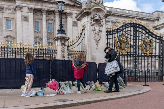 Well Wishers leave flowers and cards outside Buckingham Palace
