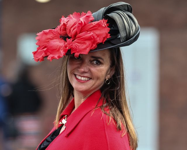 A racegoers wearing a red dress and a black hat with a big red flower arrives during the Randox Grand National Day 2024 at Aintree Racecourse, Liverpool, United Kingdom, 13th April 2024

(Photo by Mark Cosgrove/News Images)