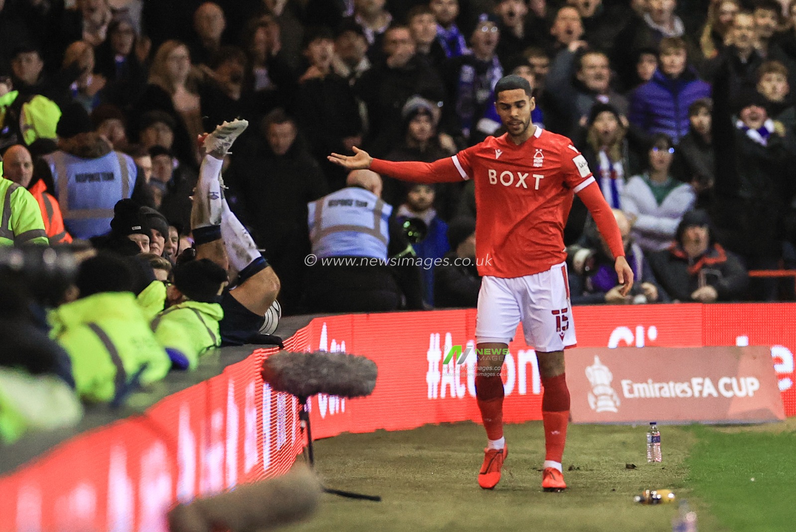 Max Lowe #15 of Nottingham Forest pushes Matty Pearson #4 of Huddersfield Town over the LED advertising board resulting in a yellow card
