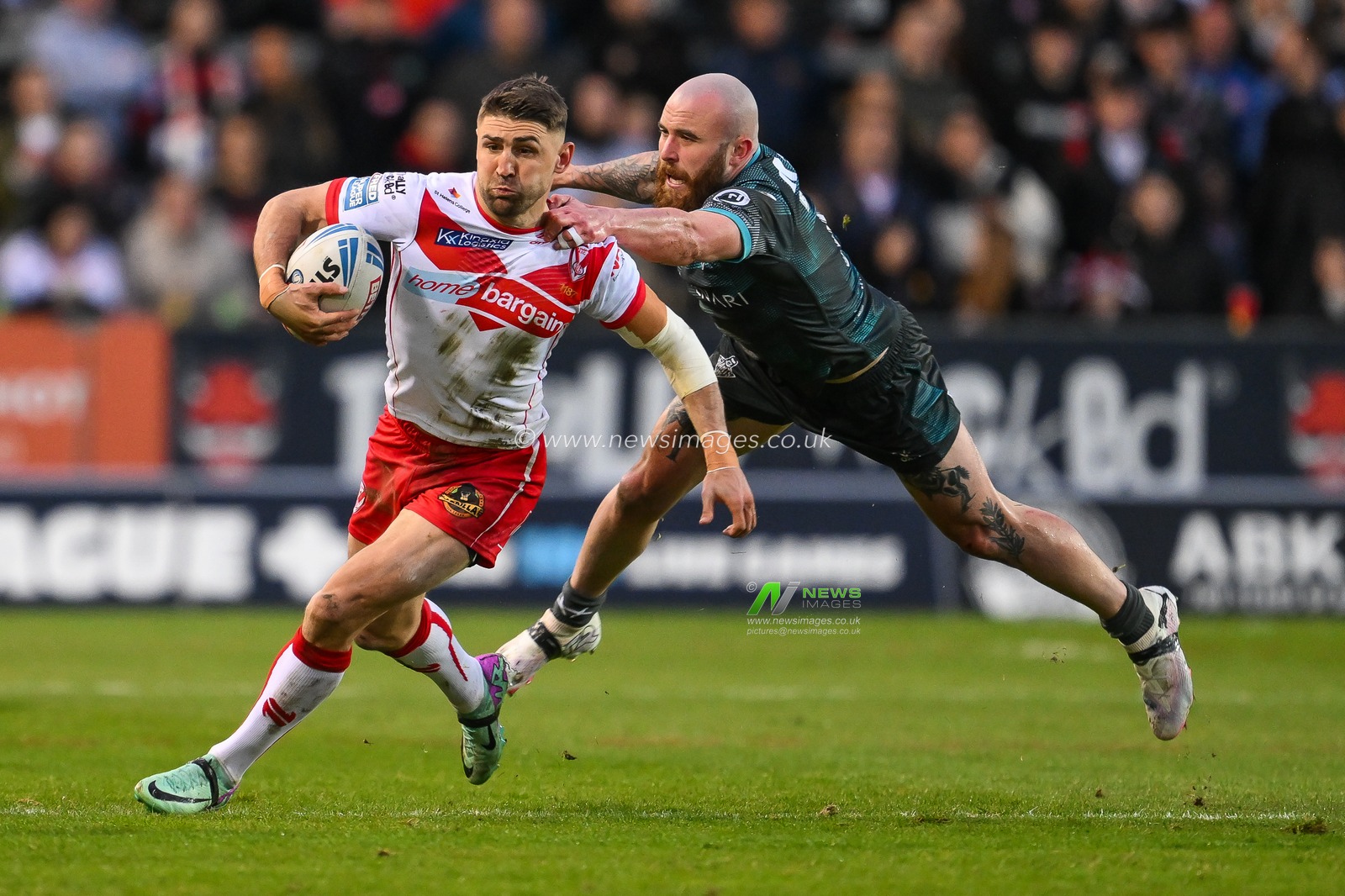 Tommy Makinson of St. Helens evades the tackle of Jake Bibby of Huddersfield Giants during the Betfred Super League Round 9 match St Helens vs Huddersfield Giants at Totally Wicked Stadium, St Helens, United Kingdom, 25th April 2024

(Photo by Craig Thomas/News Images)