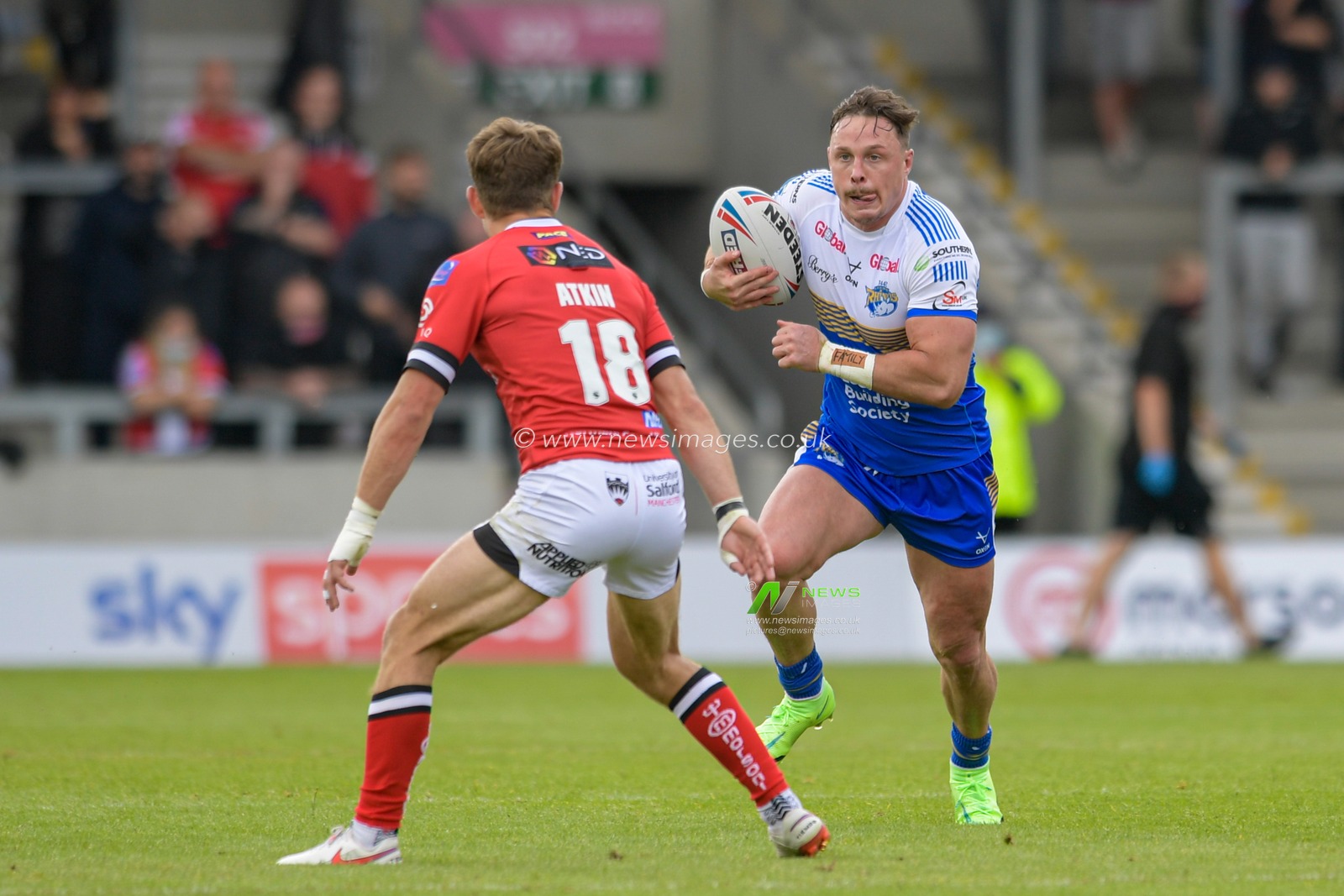James Donaldson (25) of Leeds Rhinos looks for a way past Chris Atkin (18) of Salford Red Devils
