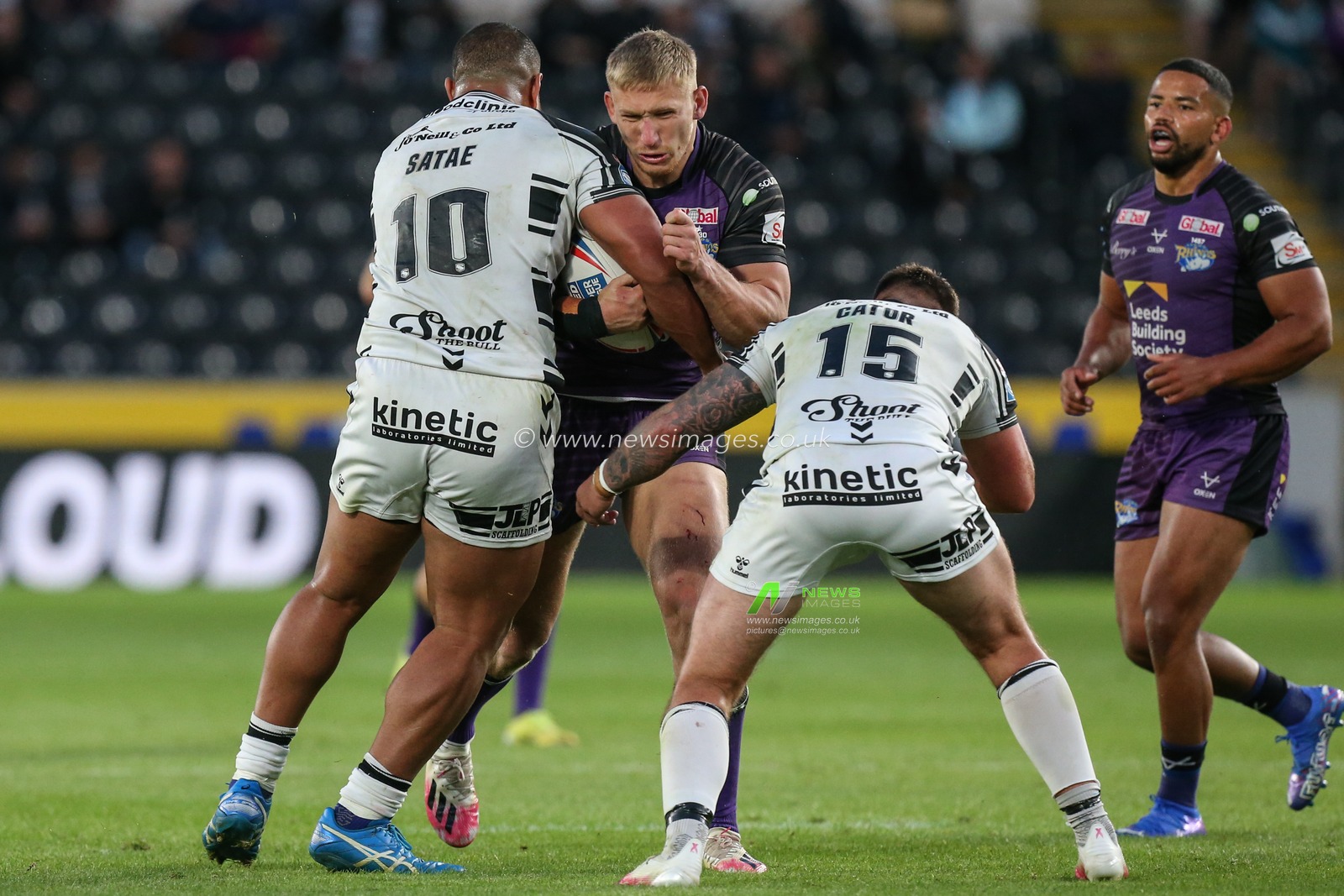 Mikolaj Oledzki (8) of Leeds Rhinos is stopped by Chris Satae (10) and Joe Cator (15) of Hull FC