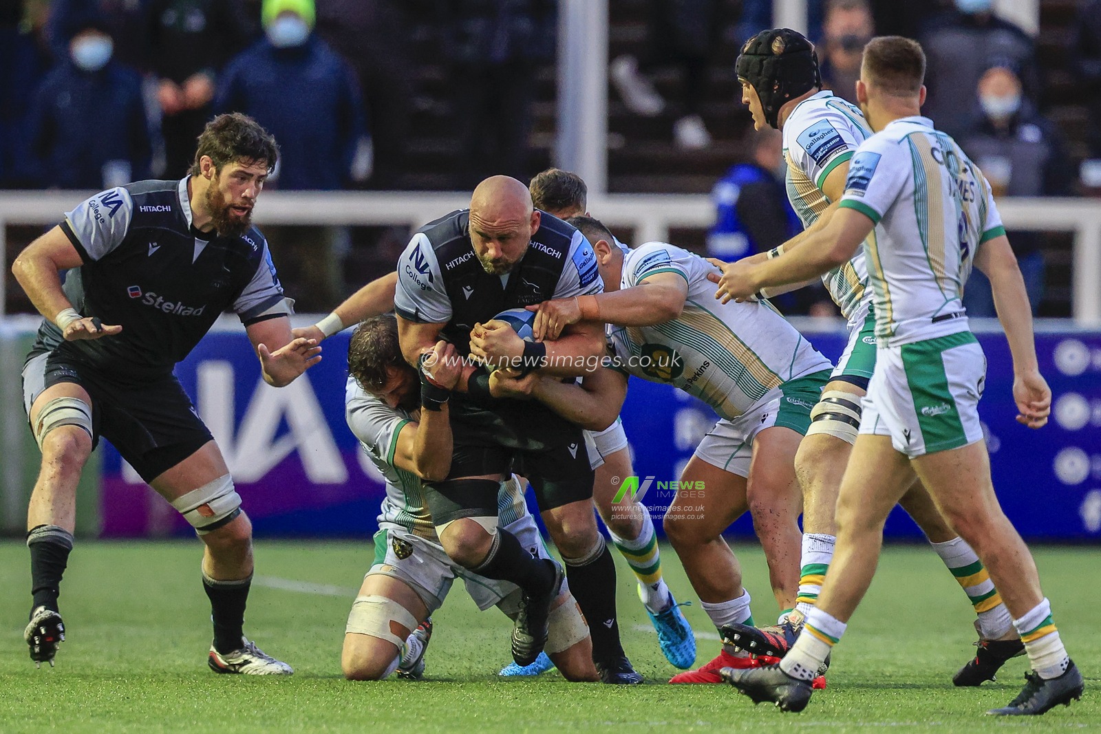 Carl Fearns of Newcastle Falcons keeps driving forward despite three Northampton Saints players trying to stop him