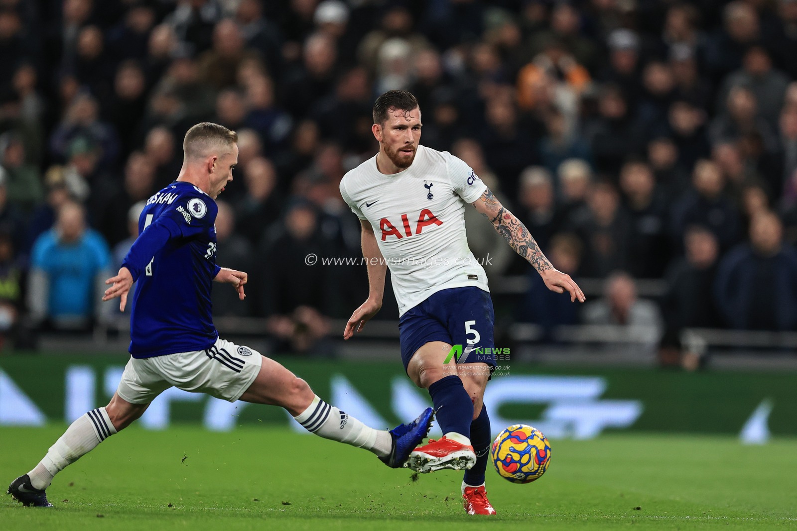 Pierre-Emile Hojbjerg #5 of Tottenham Hotspur passes the ball under pressure from Adam Forshaw #4 of Leeds United