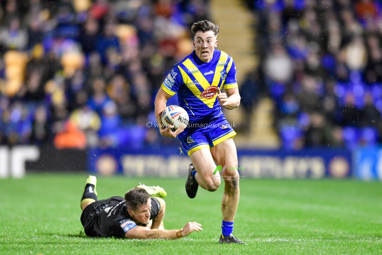 21st February 2020, Halliwell Jones Stadium, Warrington, England; Betfred Super League, Warrington Wolves v Toronto Wolfpack : Matty Ashton (26) of Warrington Wolves runs past the attempted tackle from Josh McCrone (7) of Toronto Wolfpack