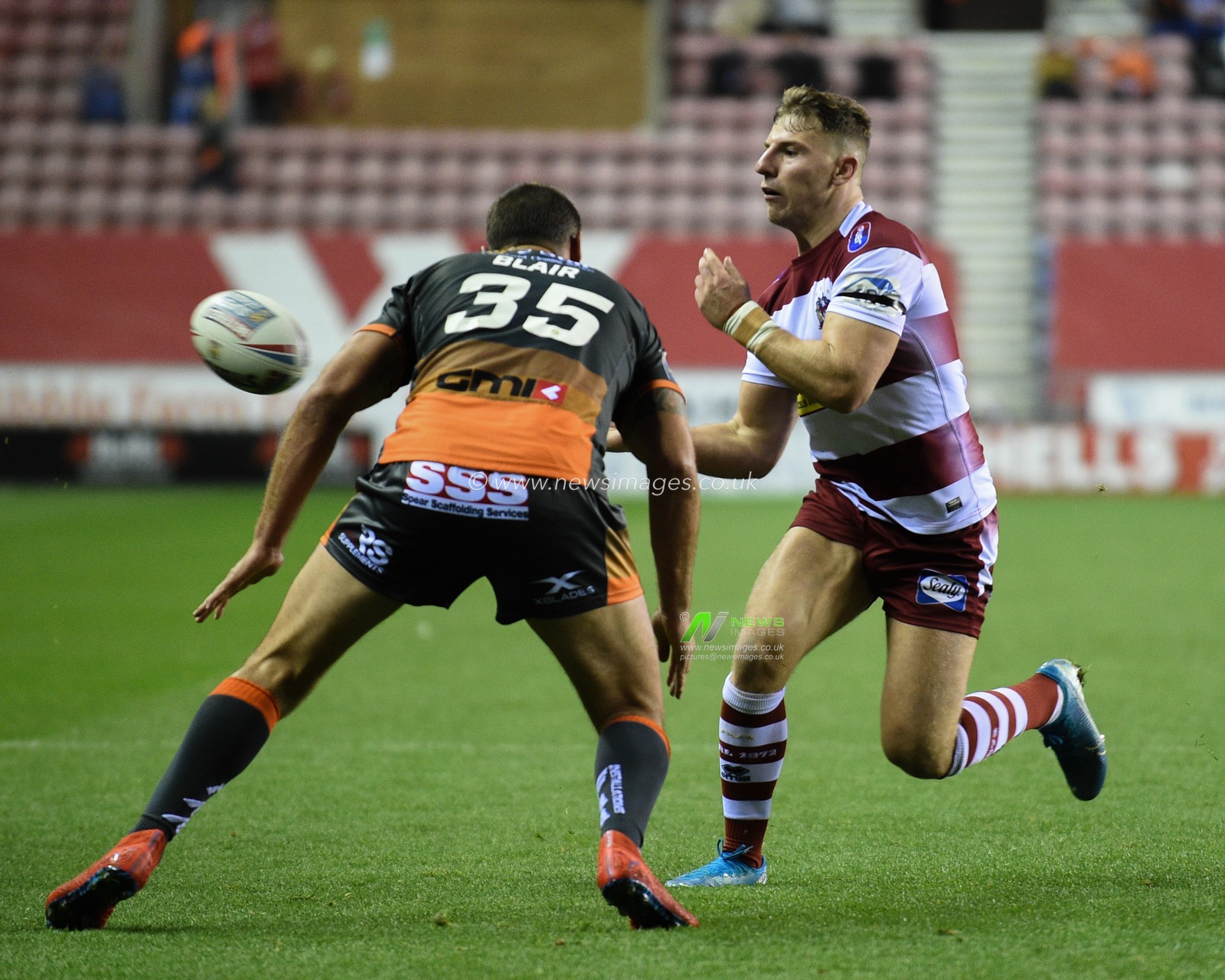 12th September 2019 , DW Stadium, Wigan, England;  Betfred Super League Rugby, Round 29, Wigan Warriors vs Castleford Tigers ; George Williams (6) of Wigan Warriors offloads ahead of Cheyse Blair (35) of Castleford Tigers 

Credit: Richard Long/News Images