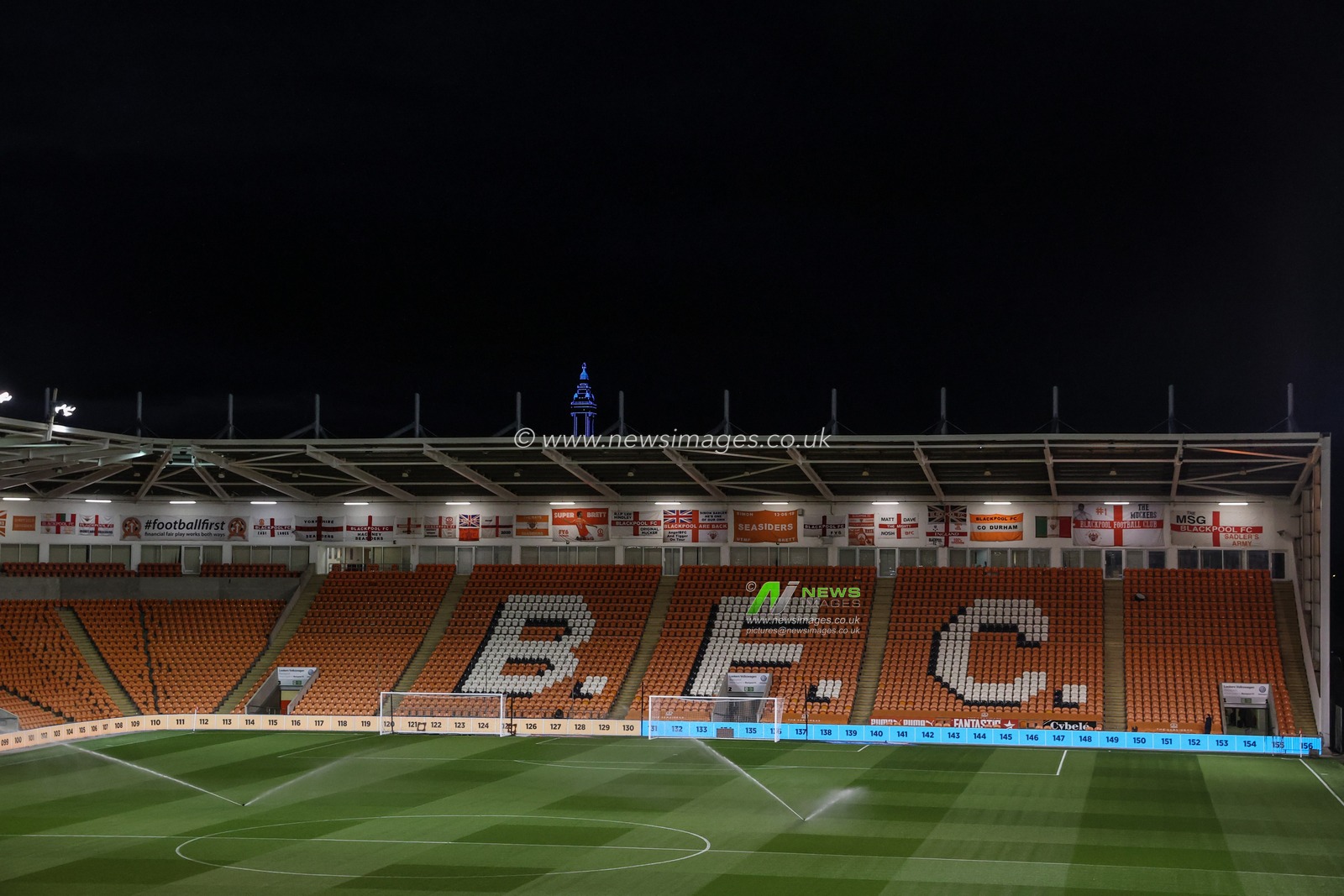 Blackpool tower is illuminated above Bloomfield Road home end