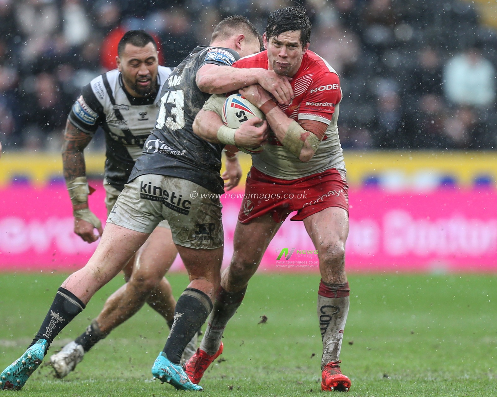 Louie McCarthy-Scarsbrook (15) of St Helens is tackled by Jordan Lane (13) of Hull FC