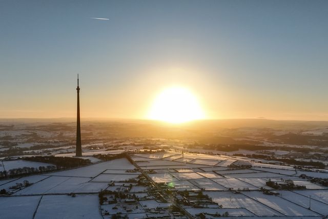 The sun sets over Emley Moor transmitting tower and the snow covered village of Emley as Sub-zero temperatures continue to hamper the north of the United Kingdom; Emley, Huddersfield, United Kingdom, 10th January 2025

(Photo by Mark Cosgrove/News Images)