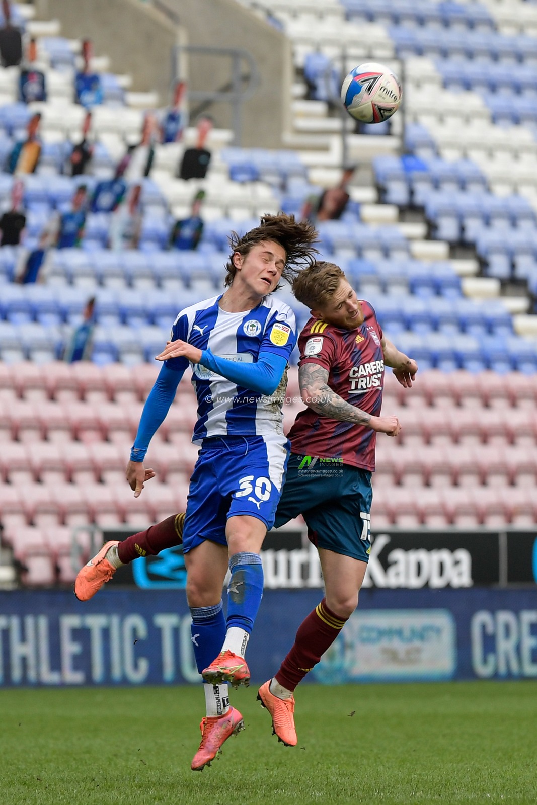Teddy Bishop #15 of Ipswich Town challenges Thelo Aasgaard #30 of Wigan Athletic in the air for the ball