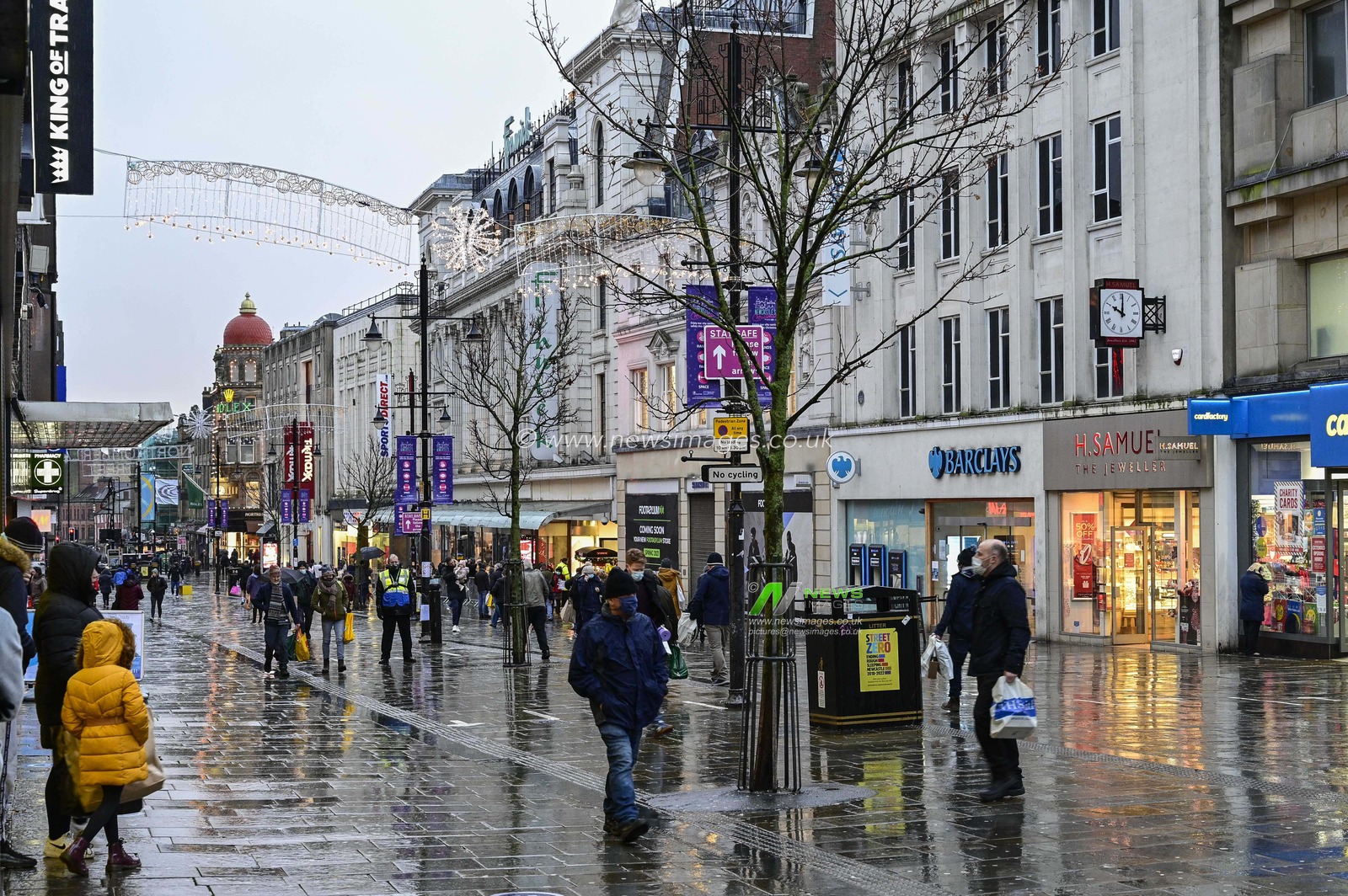 A wet Northumberland Street in Newcastle upon Tyne on Christmas Eve as shoppers venture out in the sleet