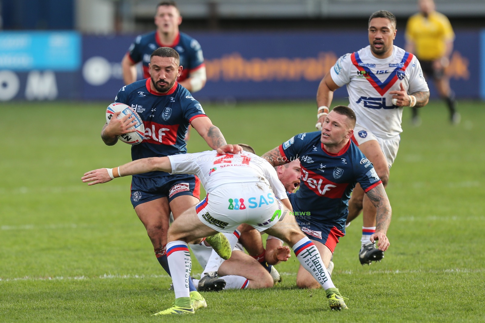 Elliot Minchella (27) of Hull KR runs at the Wakefield defence