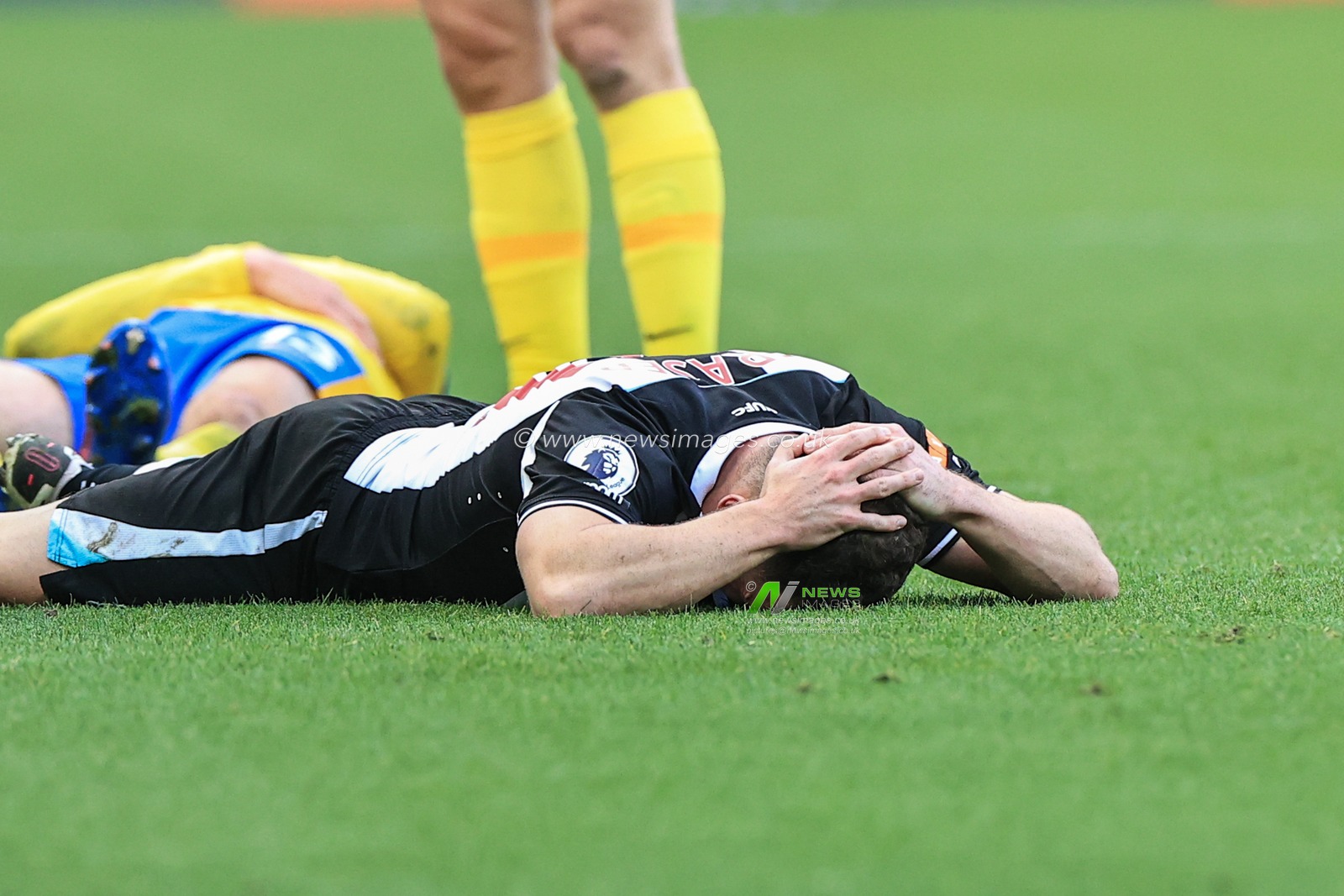 Ryan Fraser #21 of Newcastle United lays injured after a knock to the head
