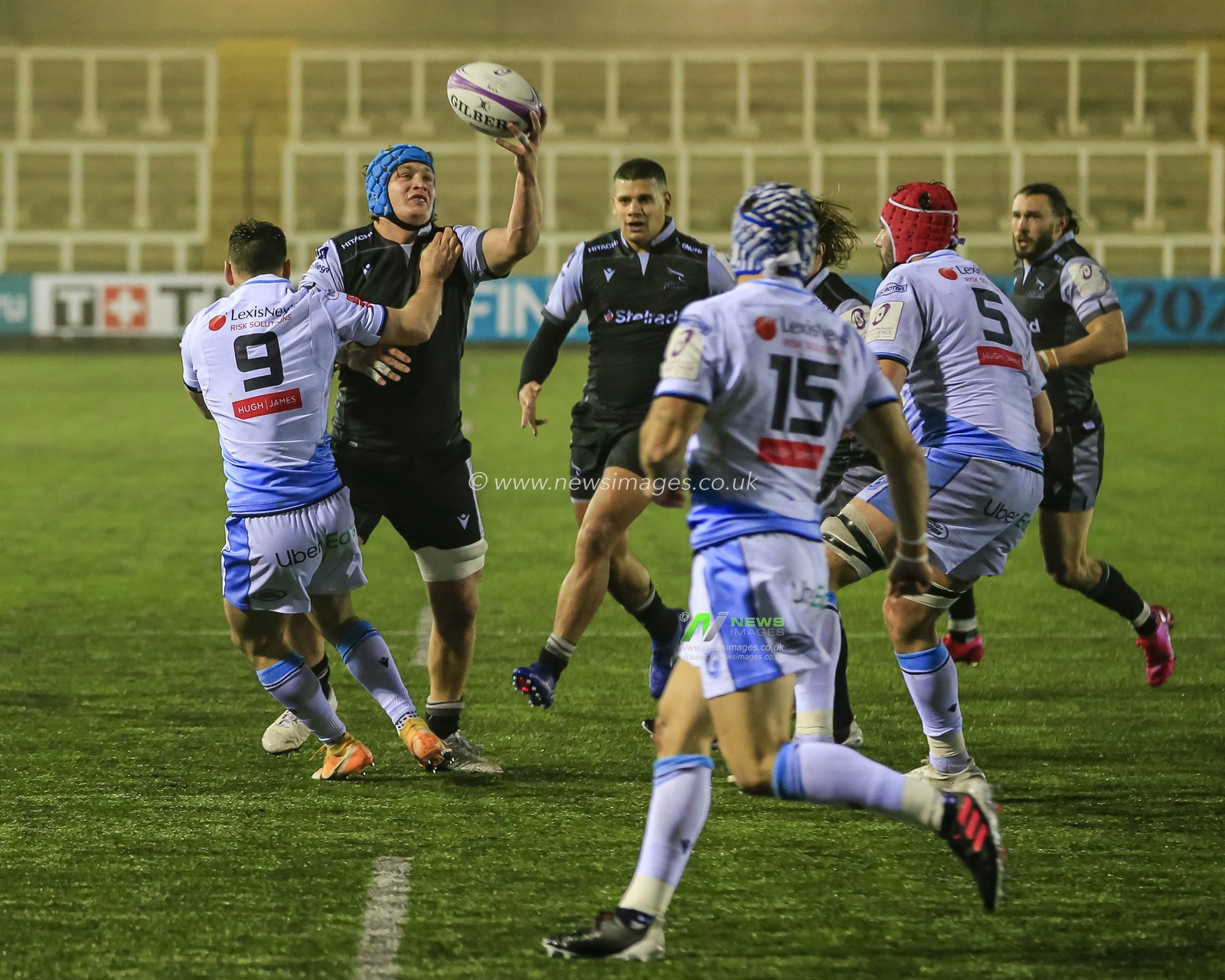 Connor Collett of Newcastle Falcons tries to catch the ball under pressure from Tomos Williams of Cardiff Blues
