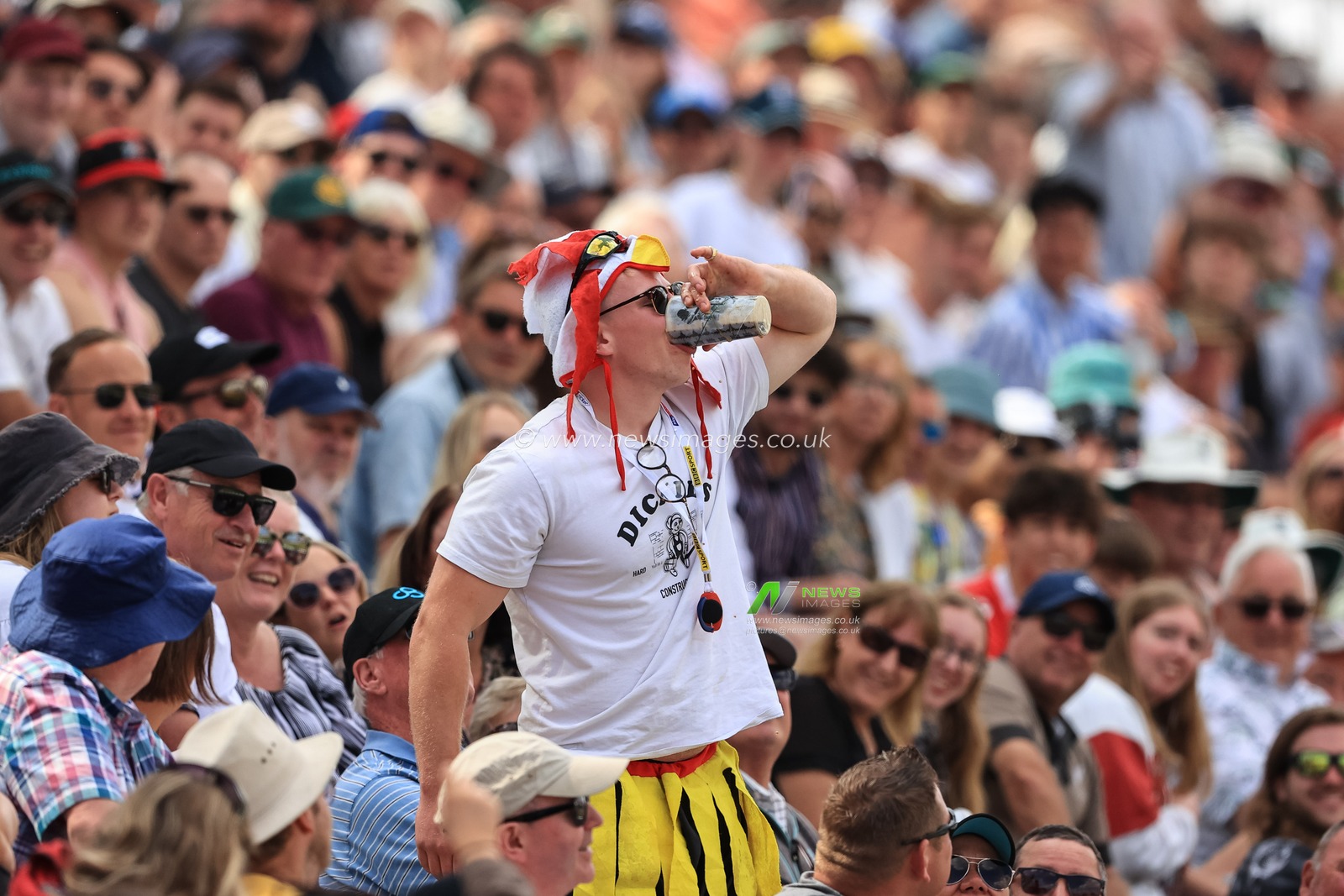 An England fan downs a pint of beer in one go as heâ€™s egged on by the whole crowd