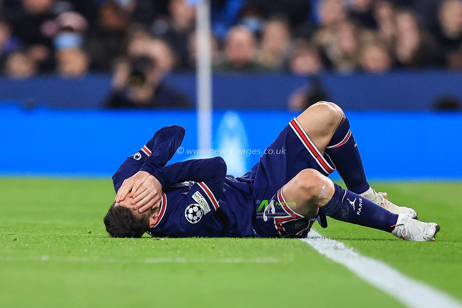 Lionel Messi #30 of Paris Saint-Germain on the floor in pain after a tackle