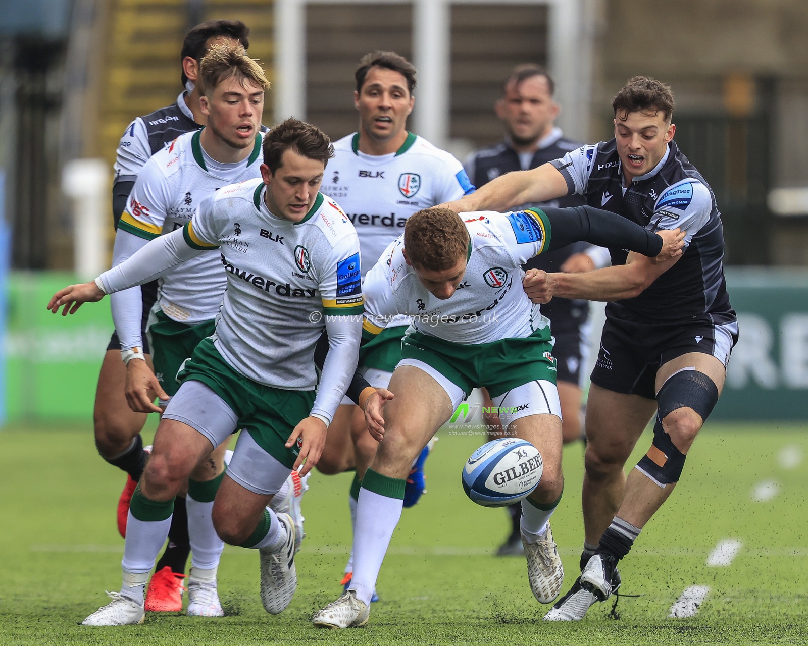 Paddy Jackson of London Irish fumbles the ball under pressure from Adam Radwan of Newcastle Falcons