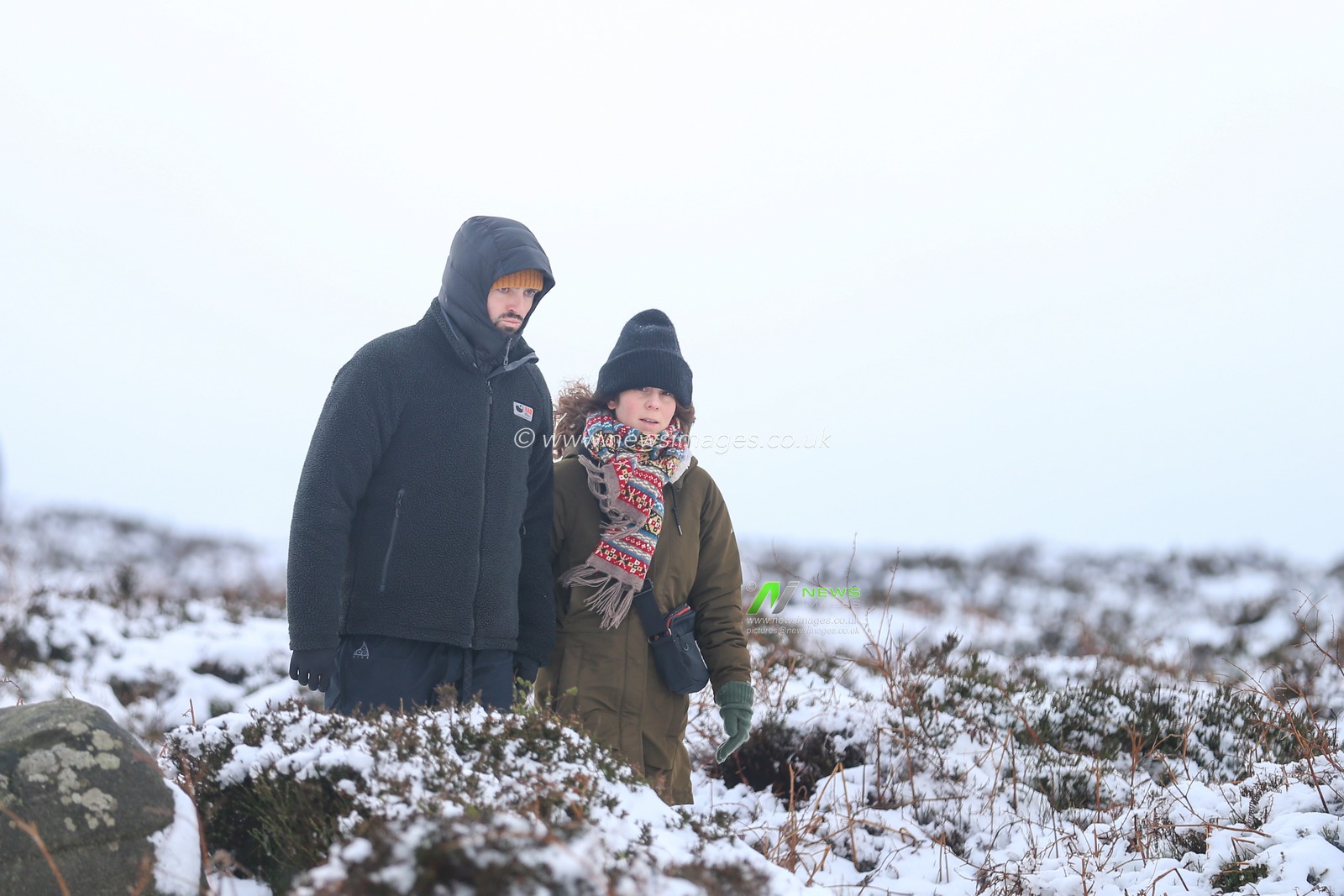 A couple take a walk in thePeak District as heavy snow falls