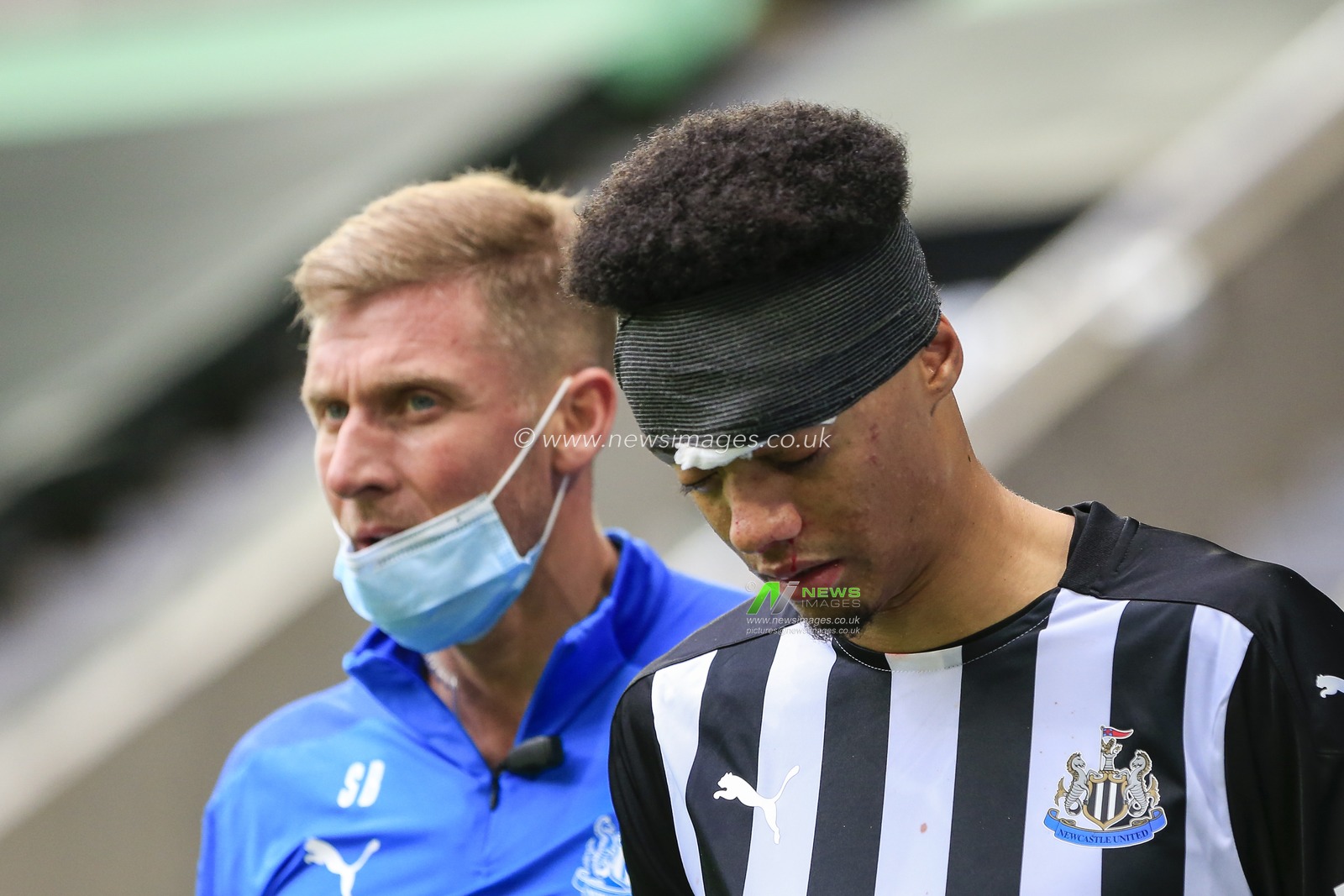 Jamal Lewis (15) of Newcastle United leaves the field after receiving a blow to the face from Yves Bissouma (8) of Brighton and Hove Albion