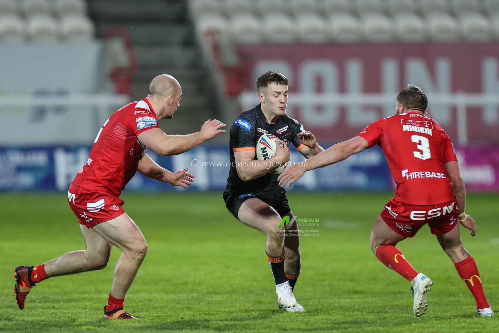 Jake Trueman (6) of Castleford Tigers runs at Greg Minikin (3) of Hull KR and George King (16) of Hull KR