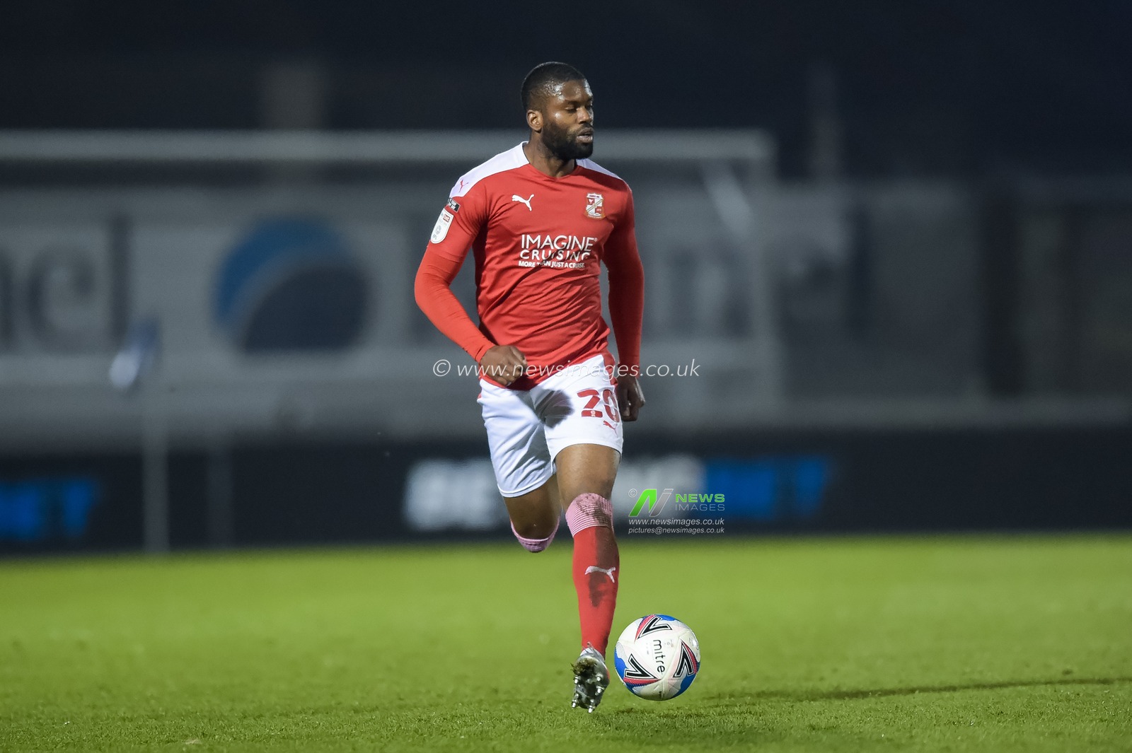 Joel Grant #20 of Swindon Town moves the ball forward for Swindon Town