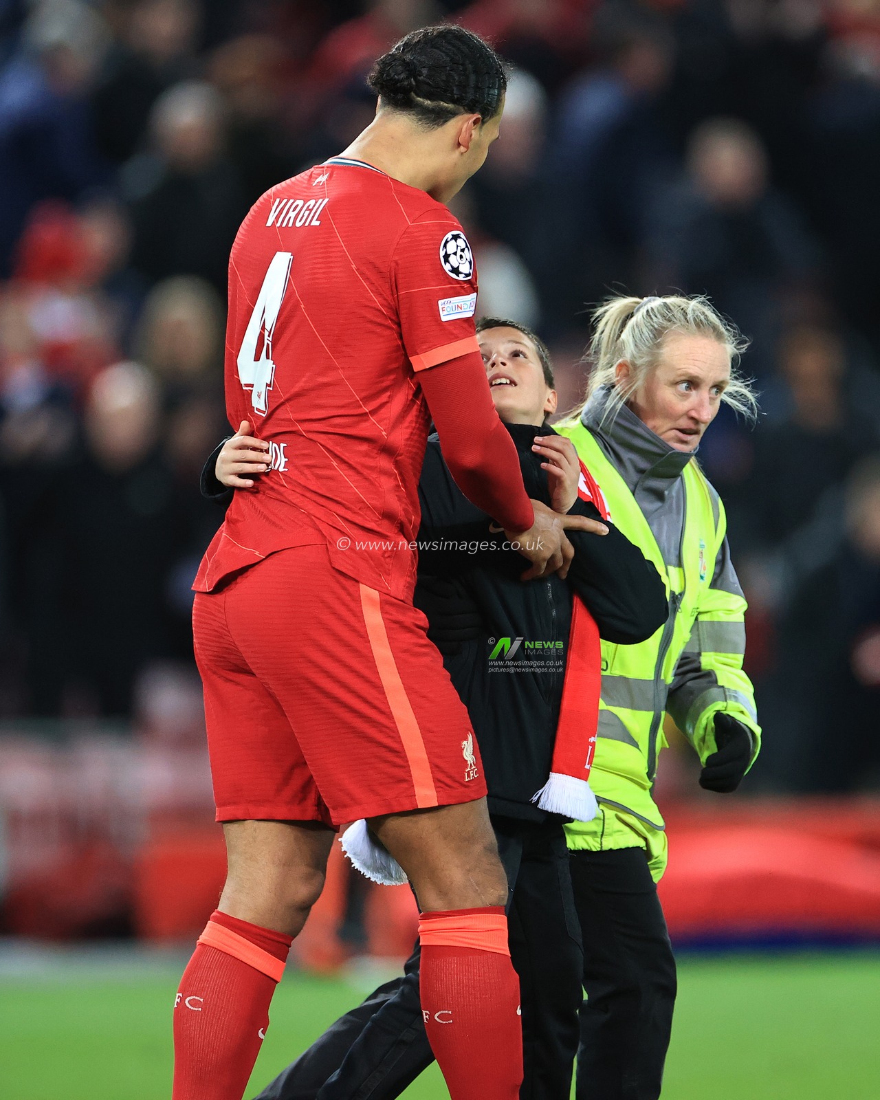 Virgil van Dijk #4 of Liverpool with a young fan