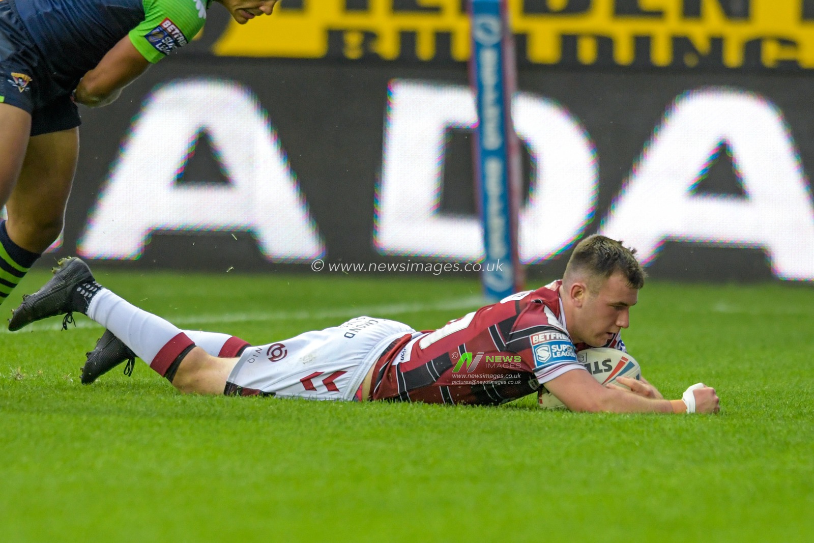 Harry Smith (20) of Wigan Warriors goes over for a try to make it 14-12