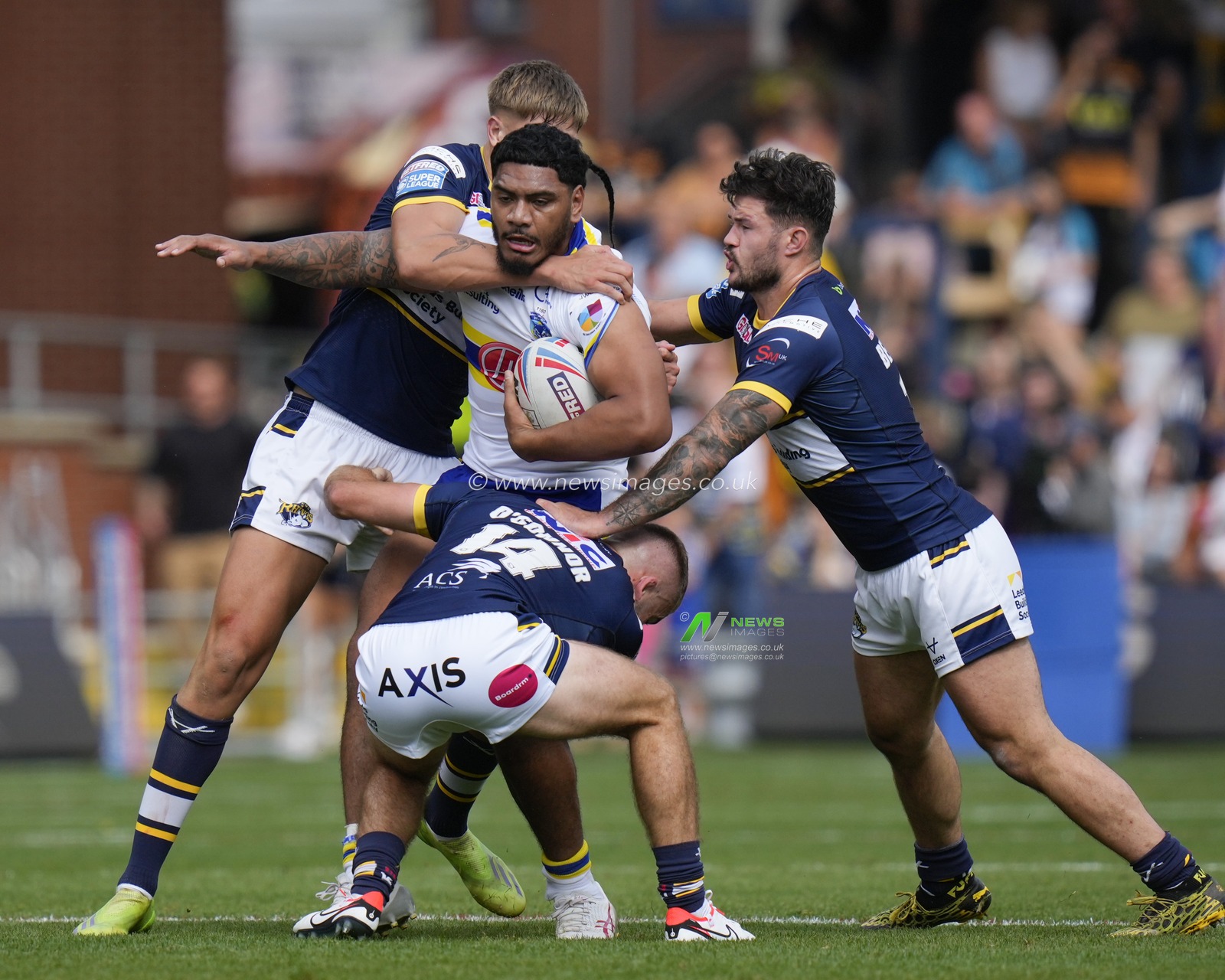 Tom Mikaele #18 of Warrington Wolves is held by the Leeds Rhinos defence during the Betfred Super League Round 22 match Leeds Rhinos vs Warrington Wolves at Headingley Stadium, Leeds, United Kingdom, 20th August 2023

(Photo by Steve Flynn/News Images)