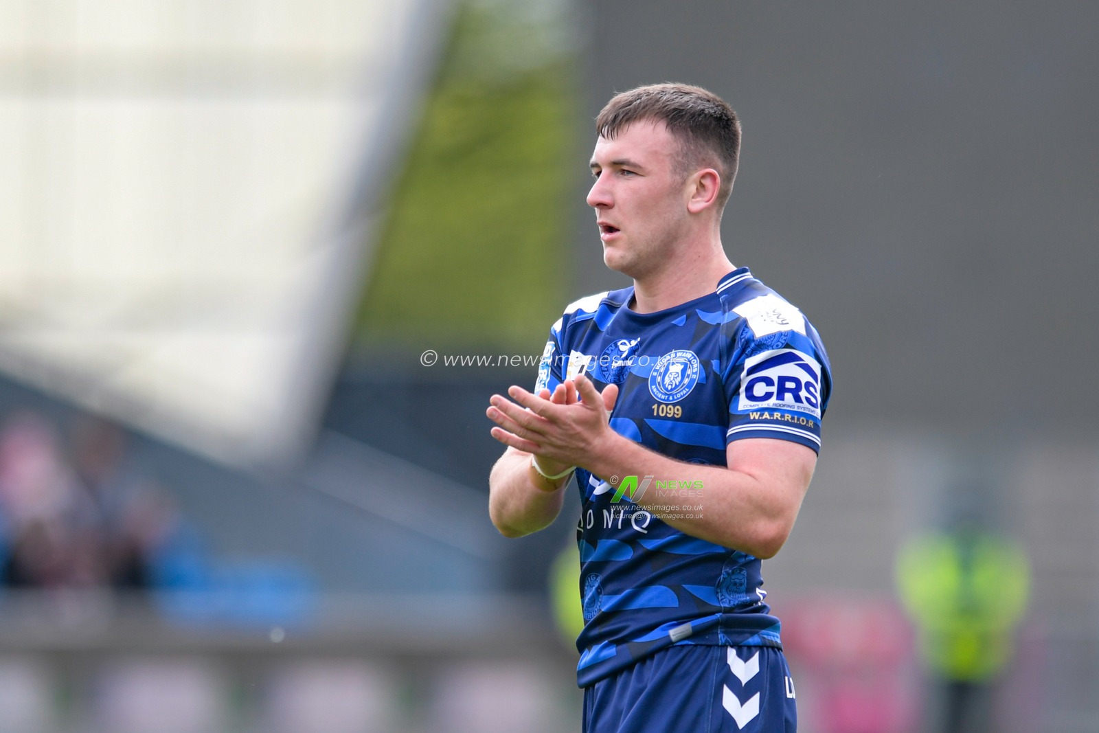 Harry Smith (20) of Wigan Warriors applauds the travelling supporters during the game