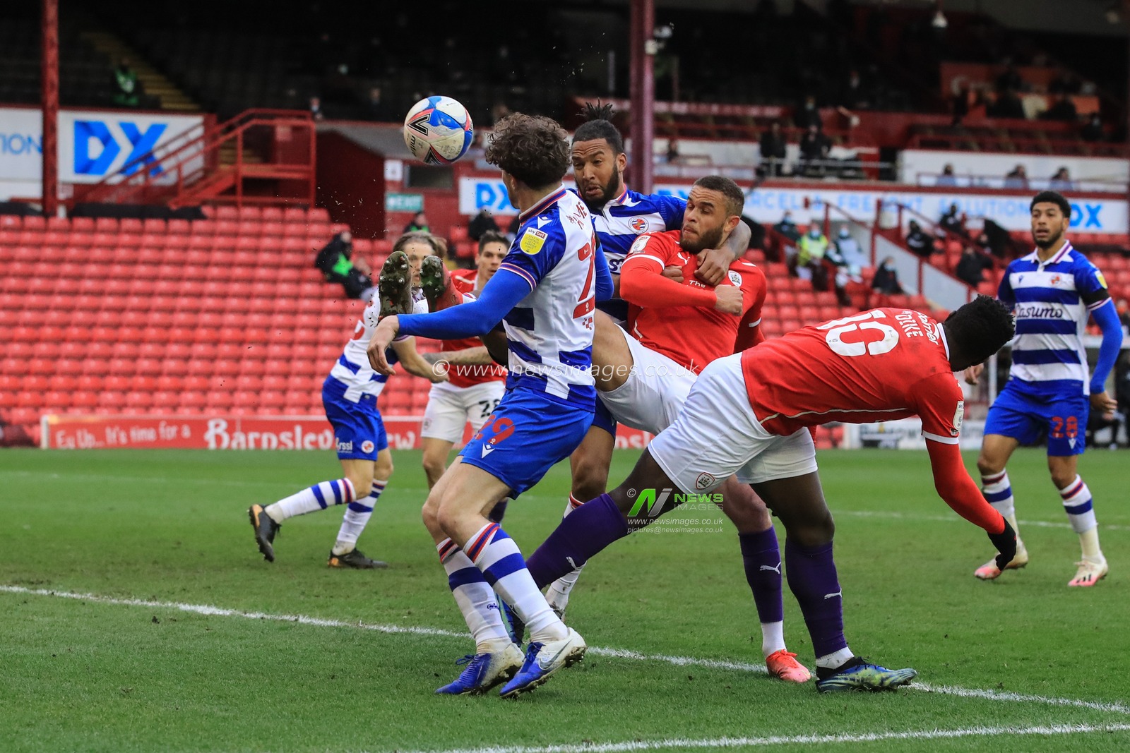Liam Moore #6 of Reading holds back Carlton Morris #14 of Barnsley on the edge of the 6 yard box