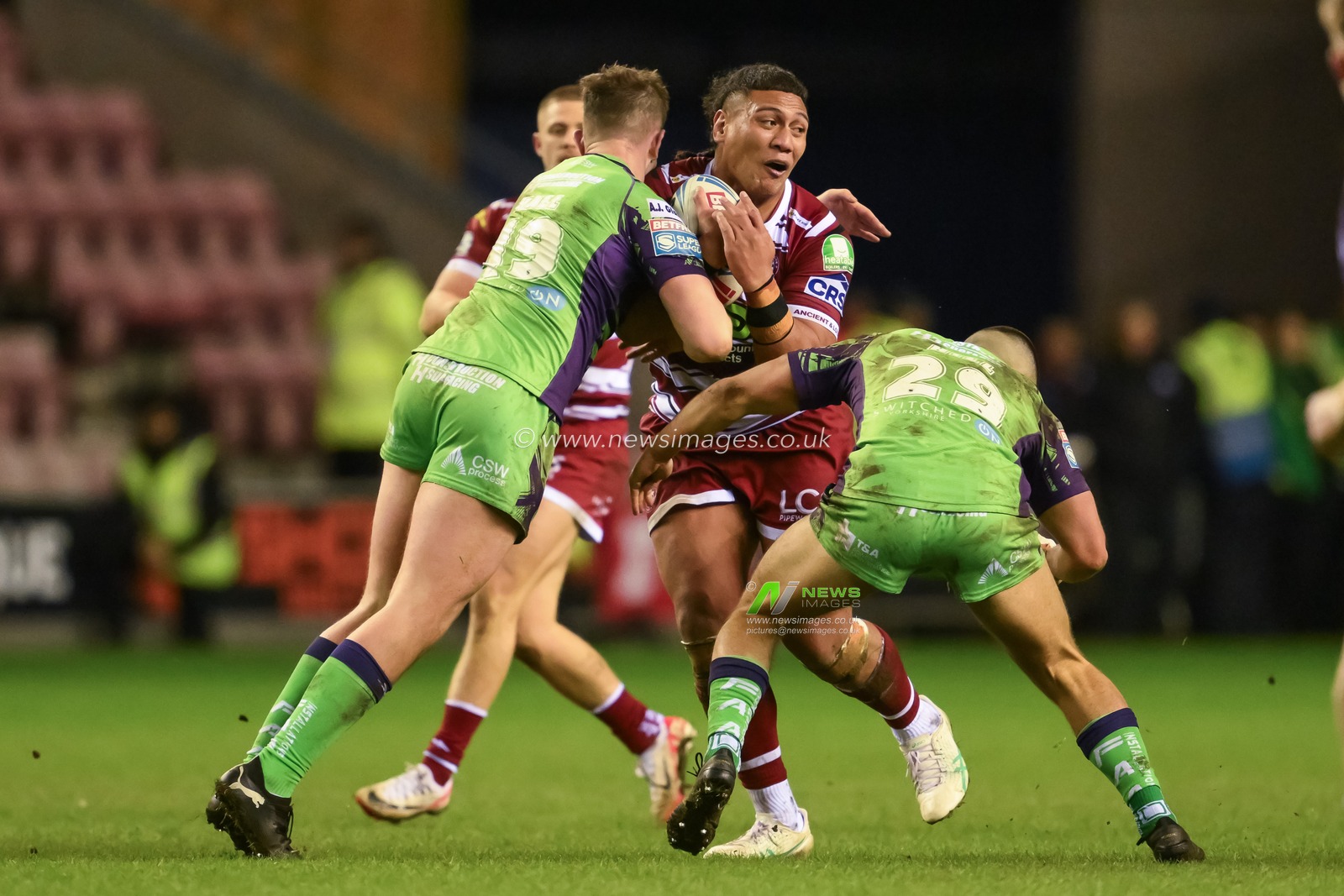 Patrick Mago of Wigan Warriors is tackled by Sam Hall of Castleford Tigers and George Hill of Castleford Tigers during the Betfred Super League Round 8 match Wigan Warriors vs Castleford Tigers at DW Stadium, Wigan, United Kingdom, 19th April 2024

(Photo by Craig Thomas/News Images)
