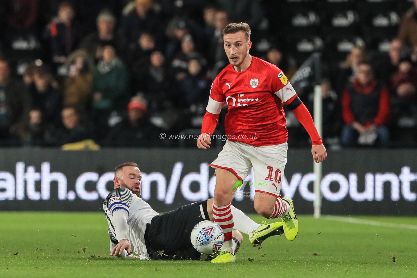 2nd January 2020, Pride Park Stadium, Derby, England; Sky Bet Championship, Derby County v Barnsley : Mike Bahre (10) of Barnsley manages to keep the ball as Wayne Rooney (32) of Derby County slides in 

Credit: Mark Cosgrove/News Images