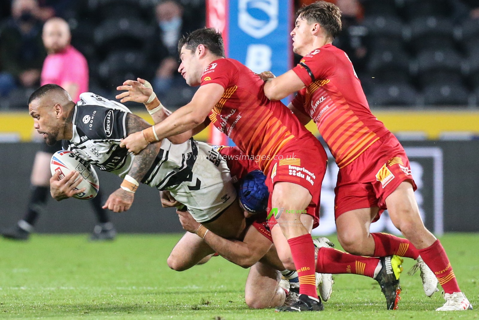 Manu Ma'u (12) of Hull FC is tackled by the Catalans defence