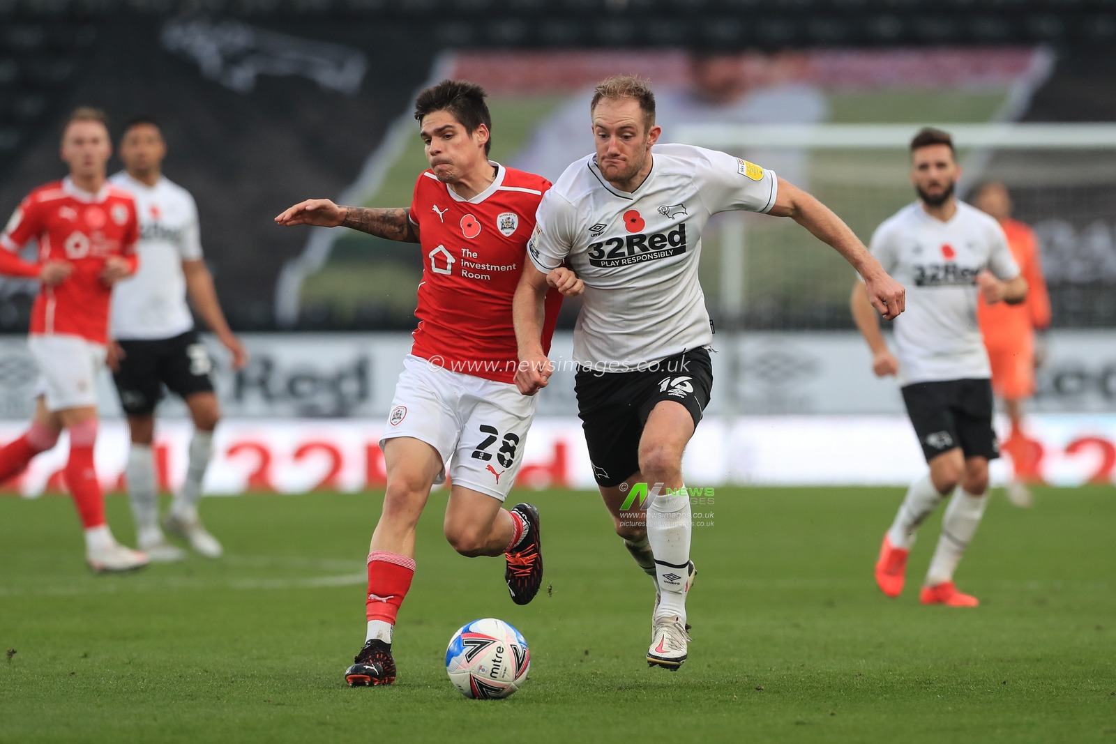 Matthew Clarke #16 of Derby County and Dominik Frieser #28 of Barnsley battle for the ball