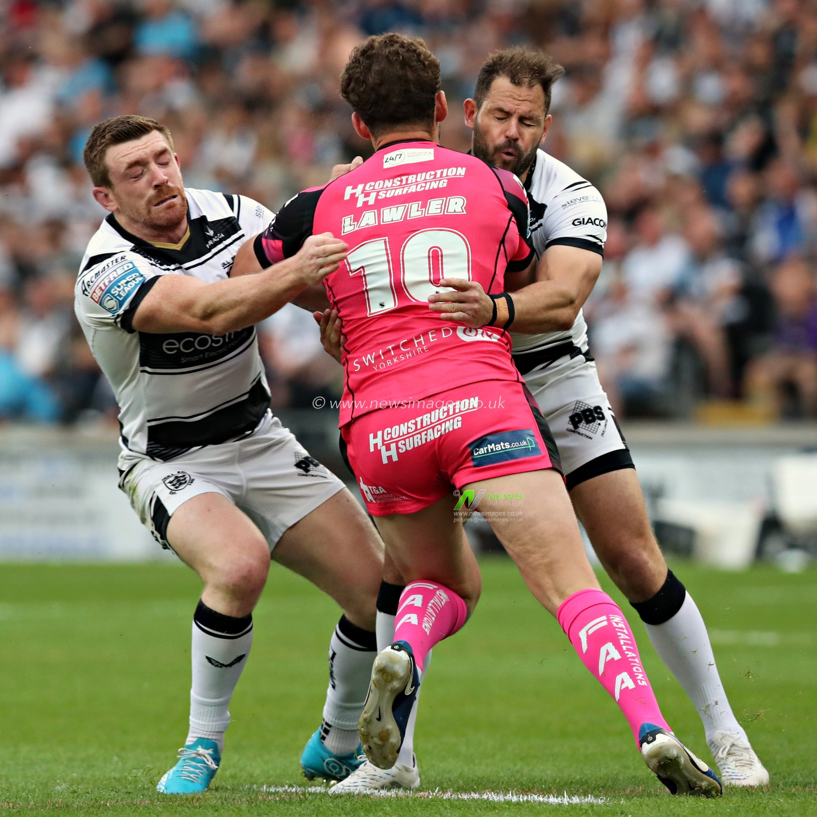 Ed Chamberlain of Hull F.C. and Aidan Sezer of Hull F.C. tackle George Lawler of Castleford Tigers during the Betfred Super League Round 14 Hull FC vs Castleford Tigers at MKM Stadium, Hull, United Kingdom, 13th June 2025(Photo by Sam Eaden/News Images)